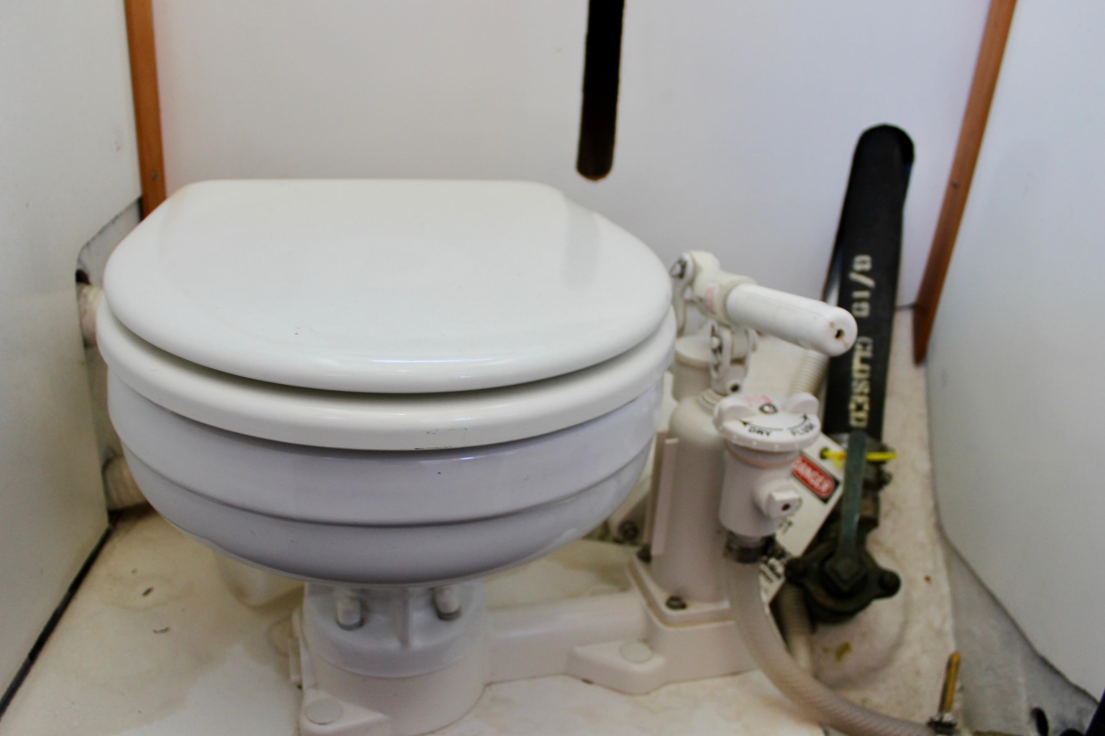 1972 Fisher 30 marine toilet with manual pump in a compact boat bathroom.