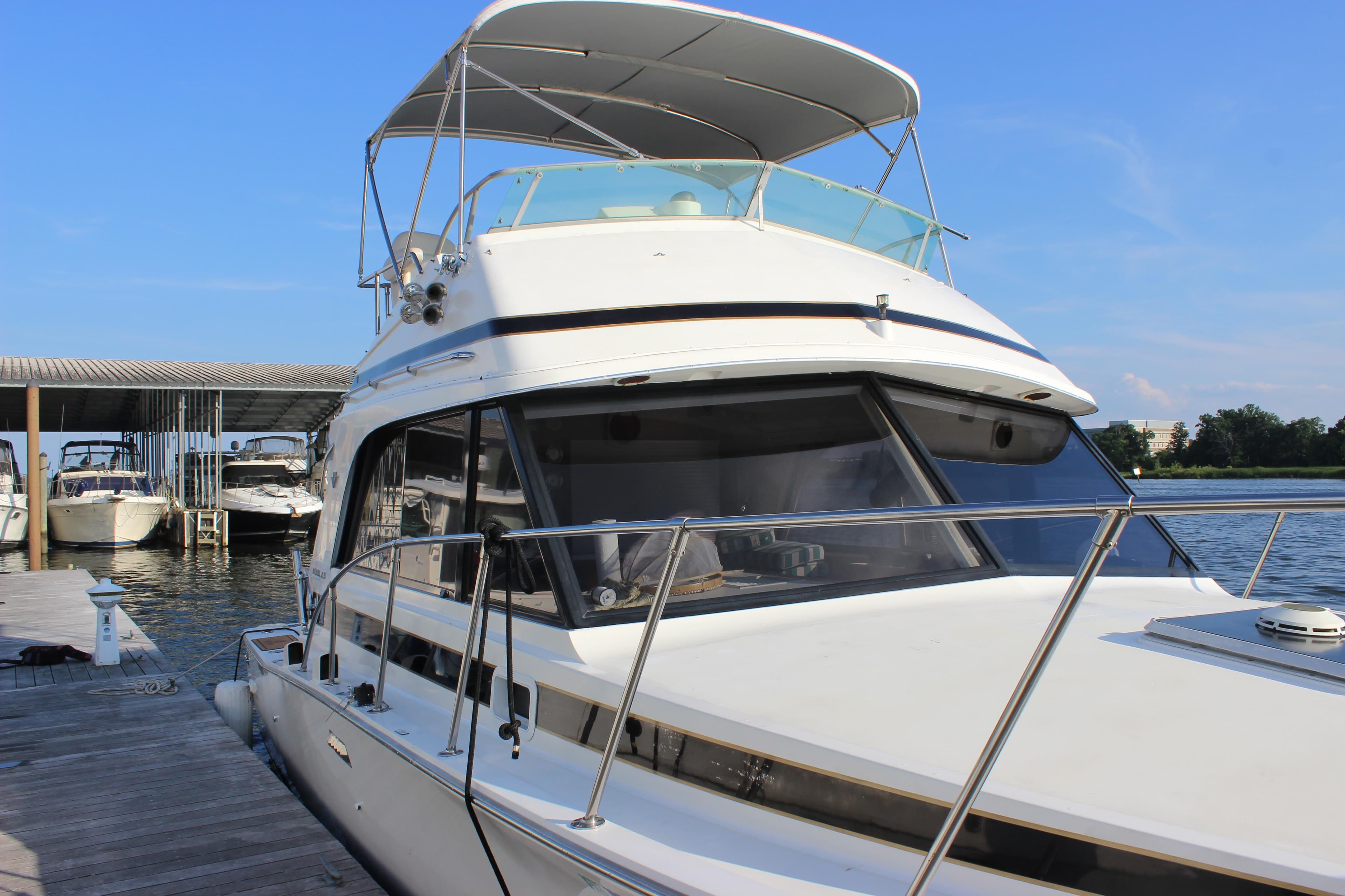 1988 Bertram 33II Flybridge Cruiser docked at marina.