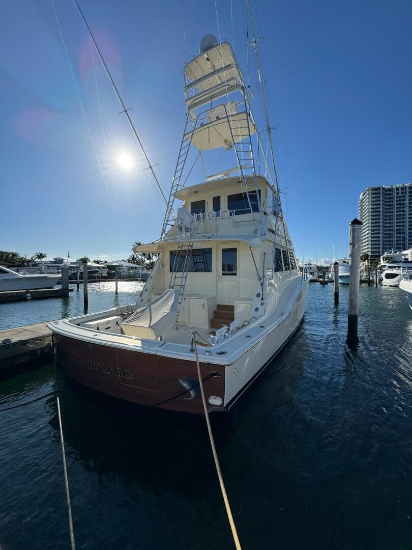 1985 Hatteras Enclosed Bridge yacht docked in sunny marina, showcasing elegant design.