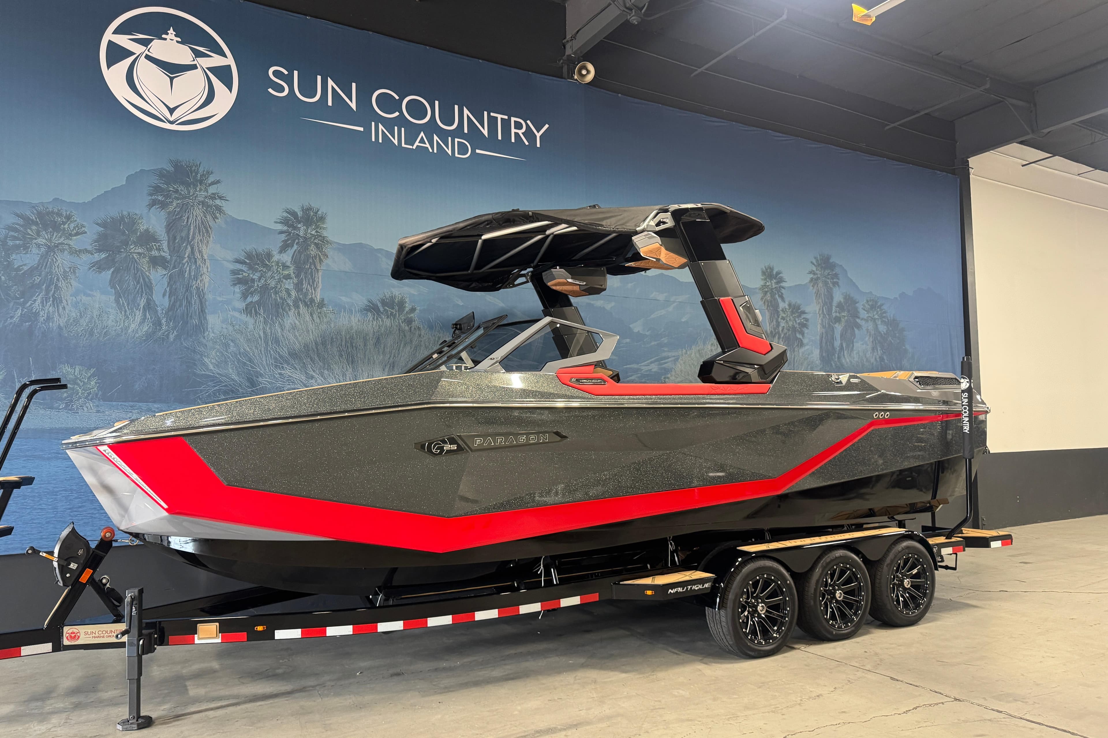 2026 Nautique Super Air Nautique G25 Paragon boat in showroom, sleek design with red accents.