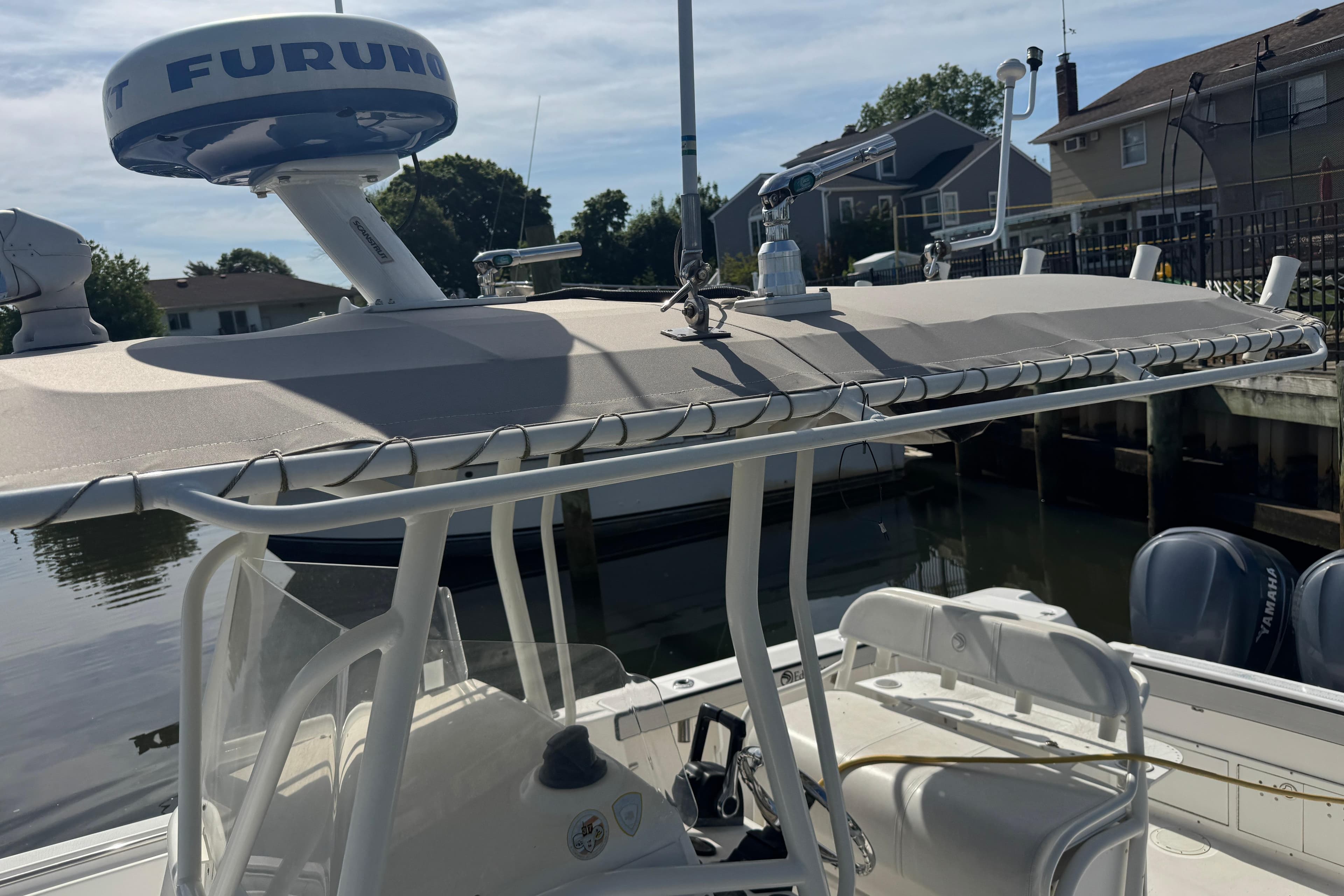2005 Edgewater 265CC boat with radar equipment docked near waterfront homes.