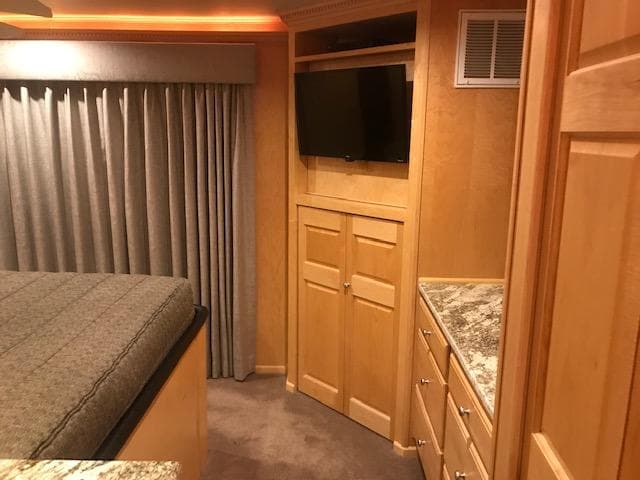 2002 Sumerset Houseboat interior bedroom with TV, wooden cabinets, and granite countertops.