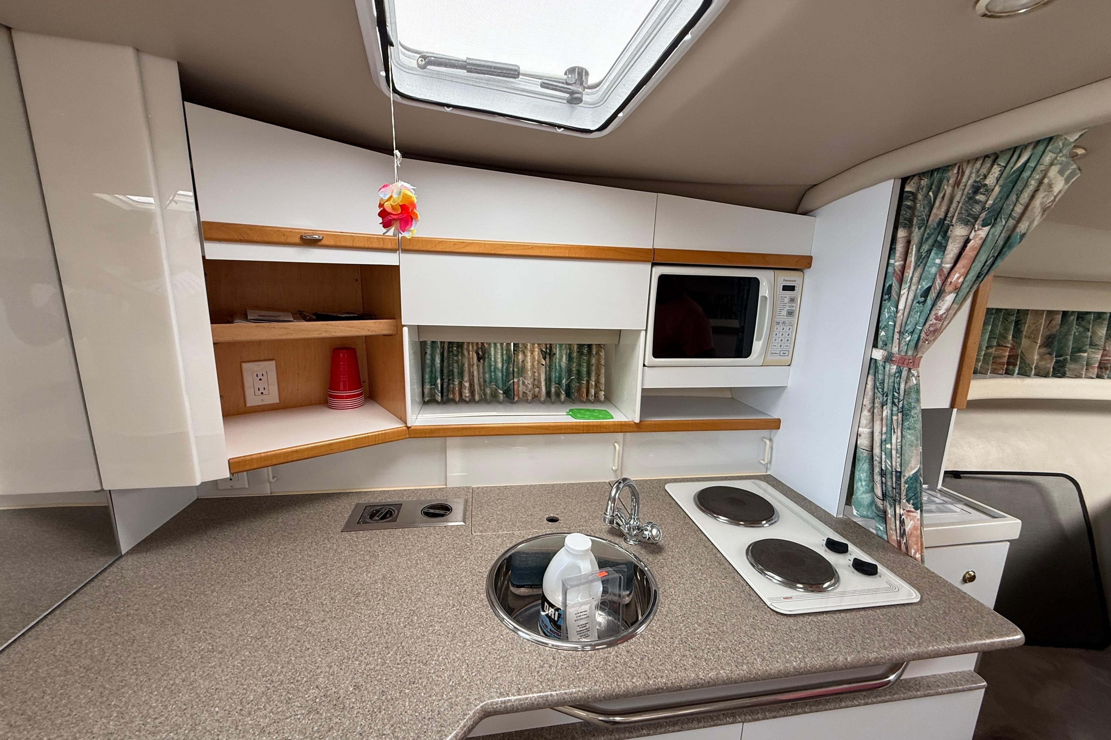 1998 Formula 34 Performance Cruiser kitchen with stove, sink, microwave, and storage cabinets.