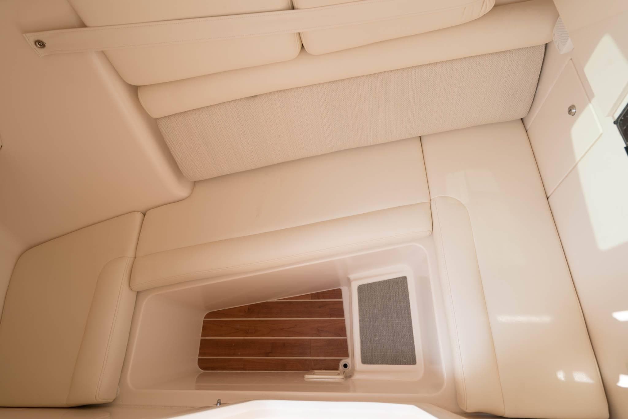 2025 Grady-White Freedom 325 interior cabin with cushioned seating and wooden flooring.