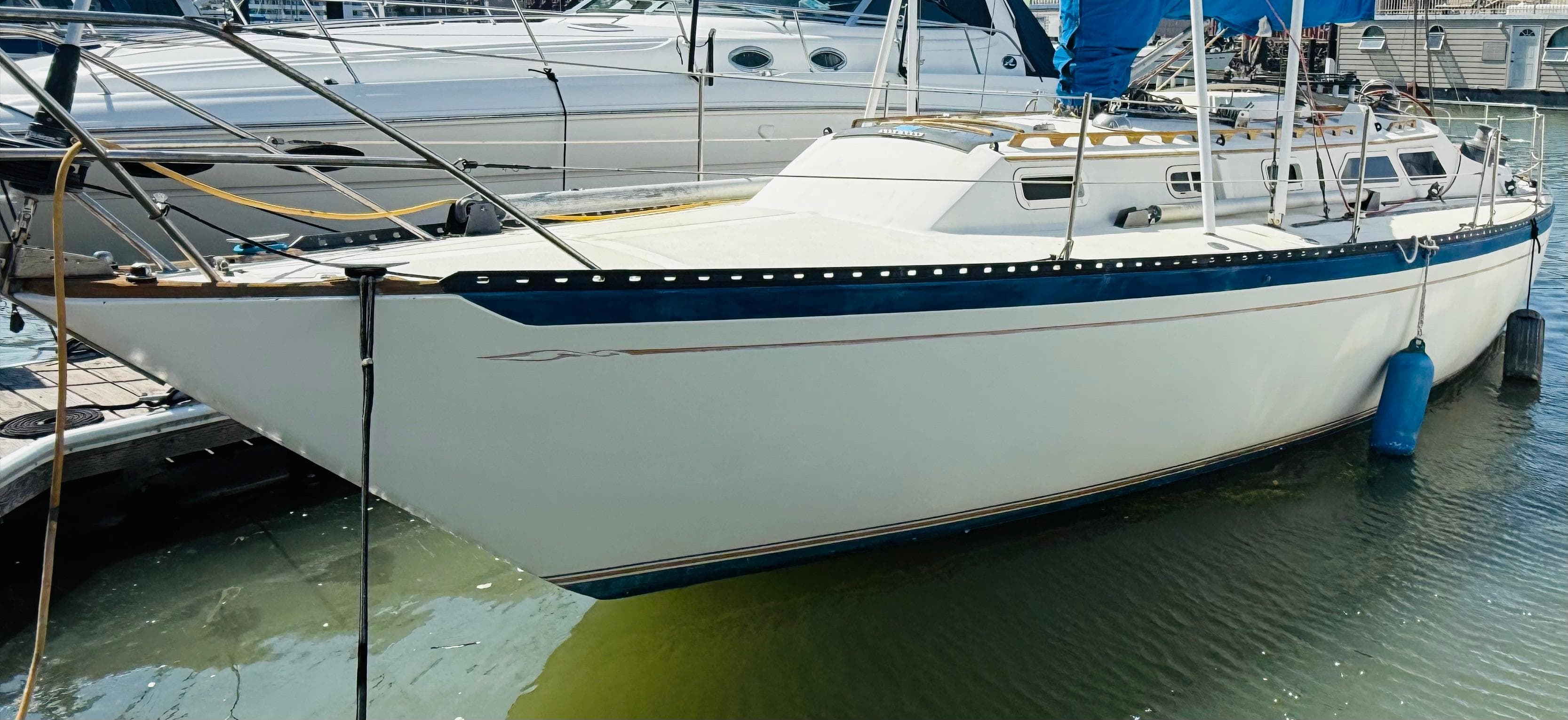 1978 Islander Sloop 36 sailboat docked in marina, white hull with blue accents.