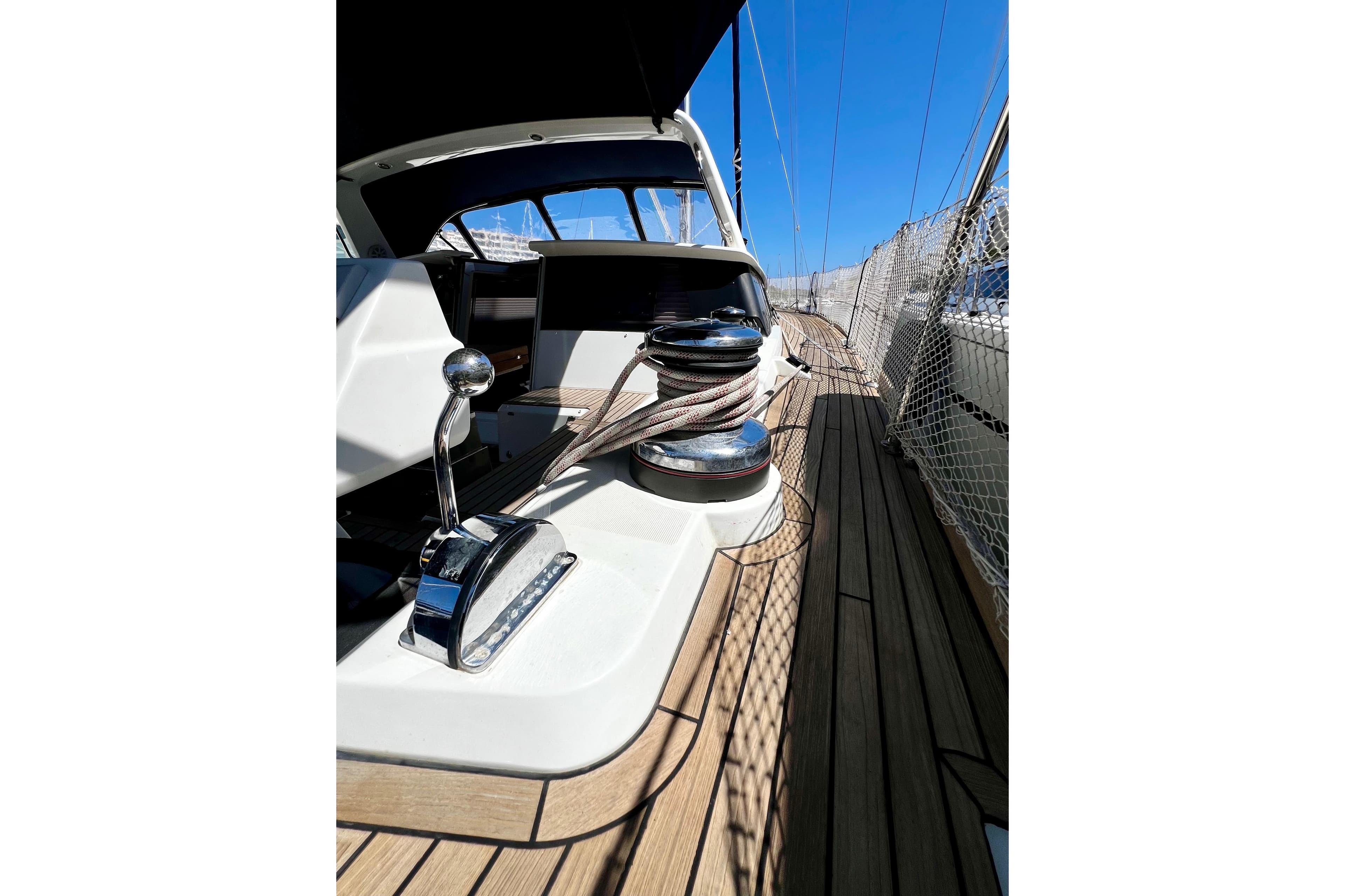 2018 Beneteau Sense 51 yacht deck with winch and control lever, under clear blue sky.