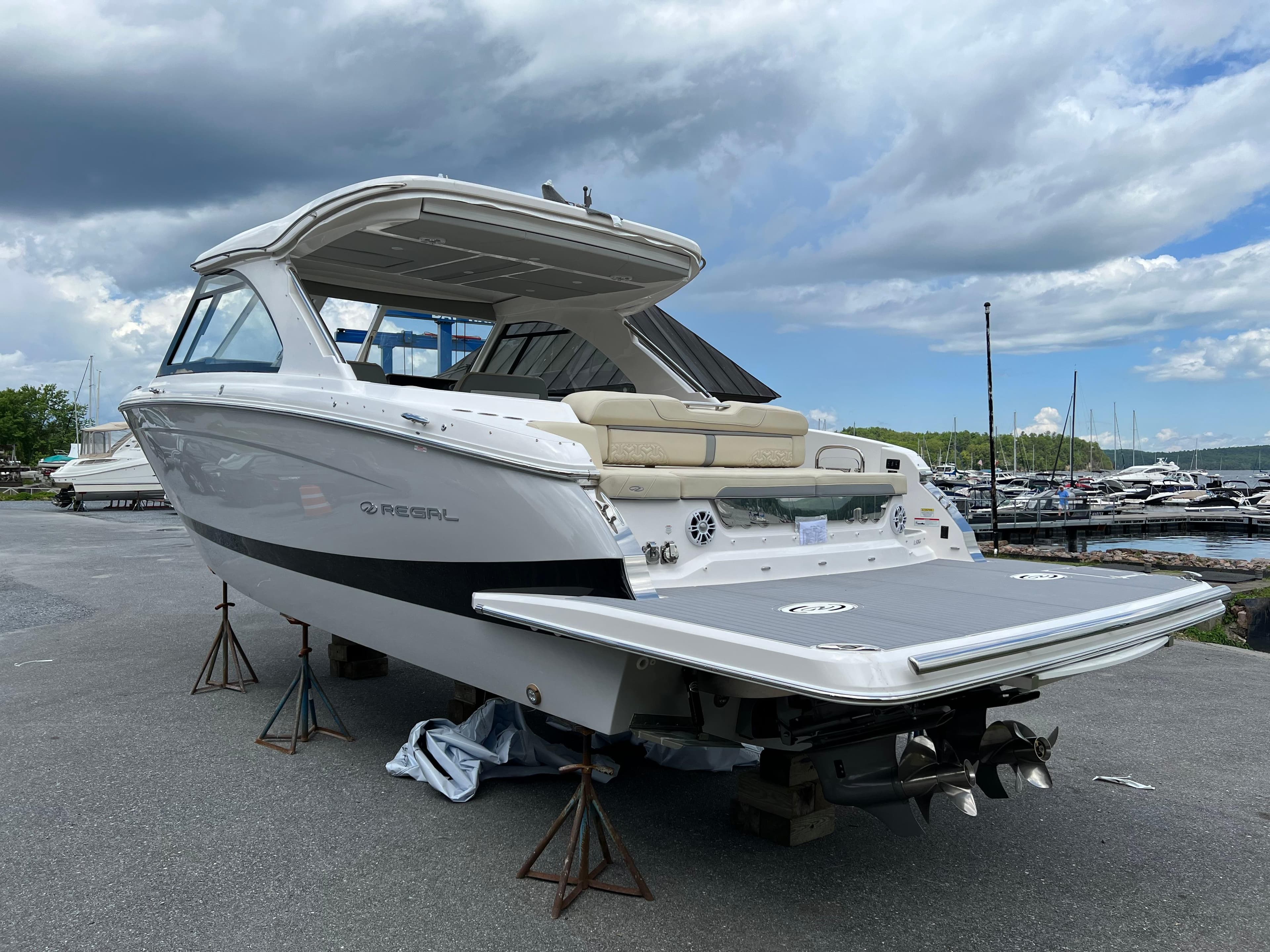2022 Regal LS36 boat on stands, marina background, cloudy sky.