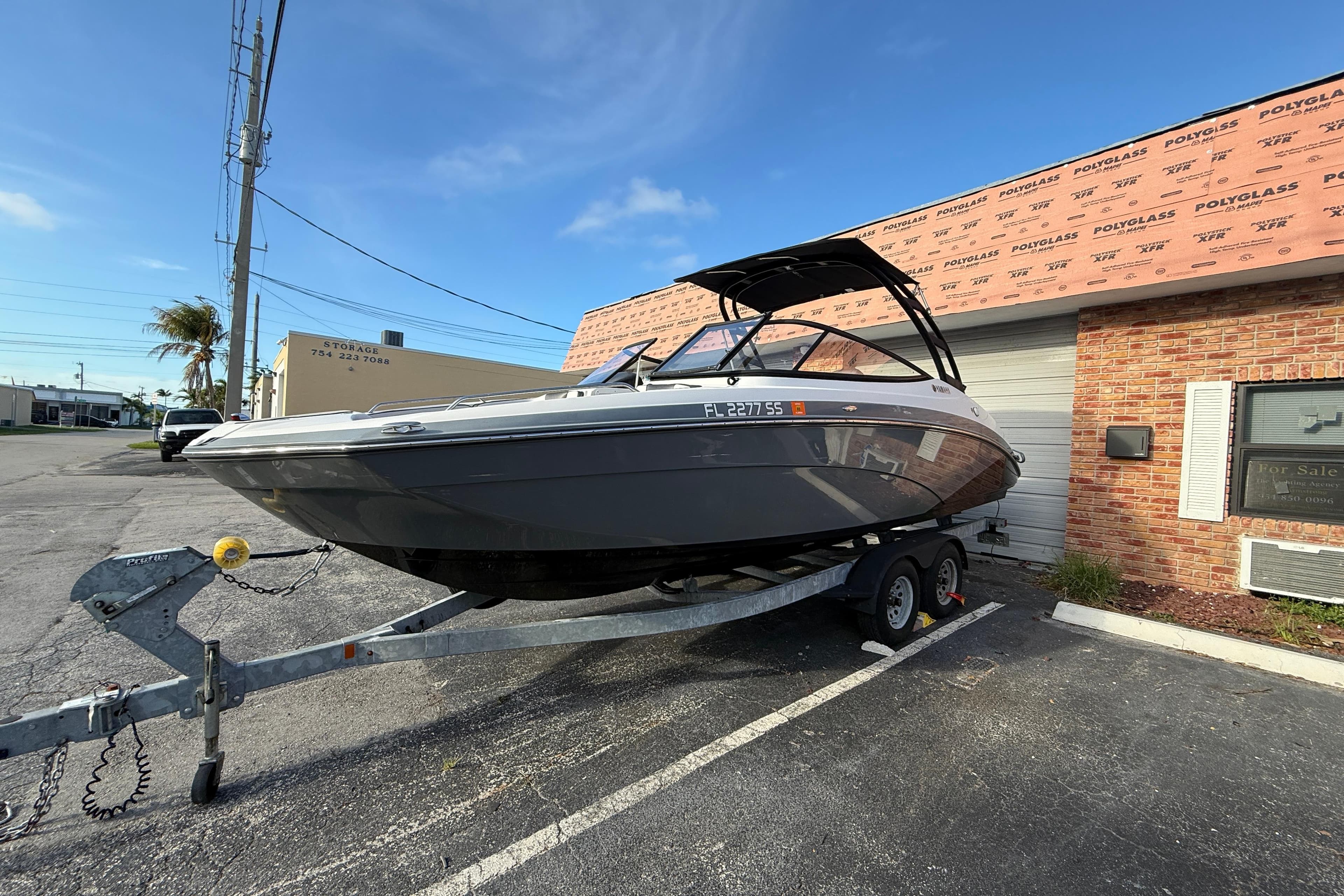 2020 Yamaha AR230 boat on trailer in parking lot, sunny day.