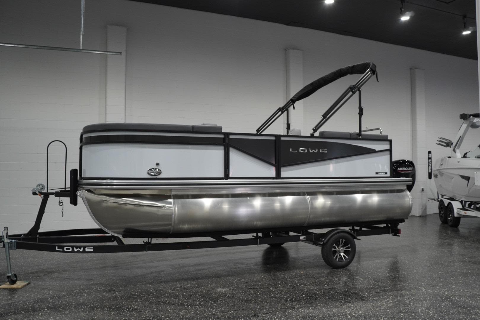 2026 Lowe LS 190 pontoon boat on trailer in showroom setting.