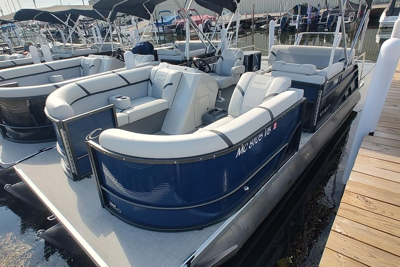 2023 Crest Classic LX 220 pontoon boat docked, featuring spacious seating and modern design.
