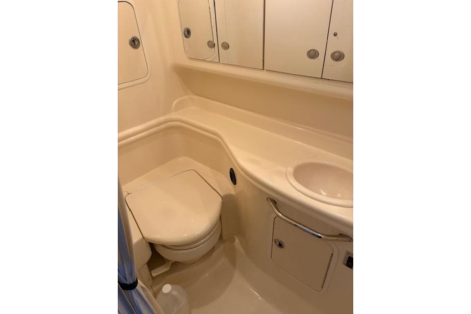 Compact bathroom in 2005 Sea Ray Sundancer 320 yacht, featuring toilet and sink.