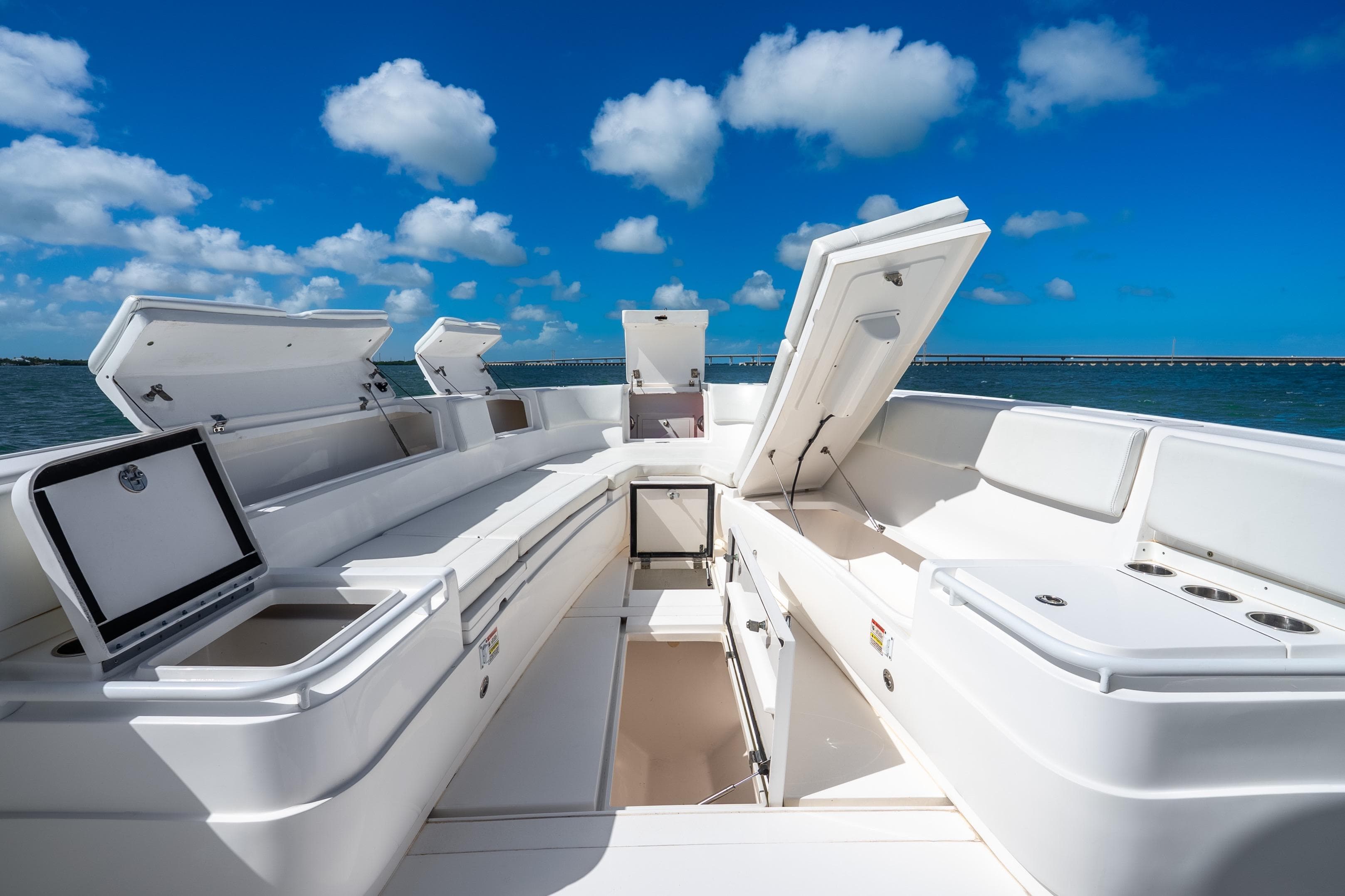 2016 Intrepid 400 Center Console boat with open storage compartments, under a clear blue sky.