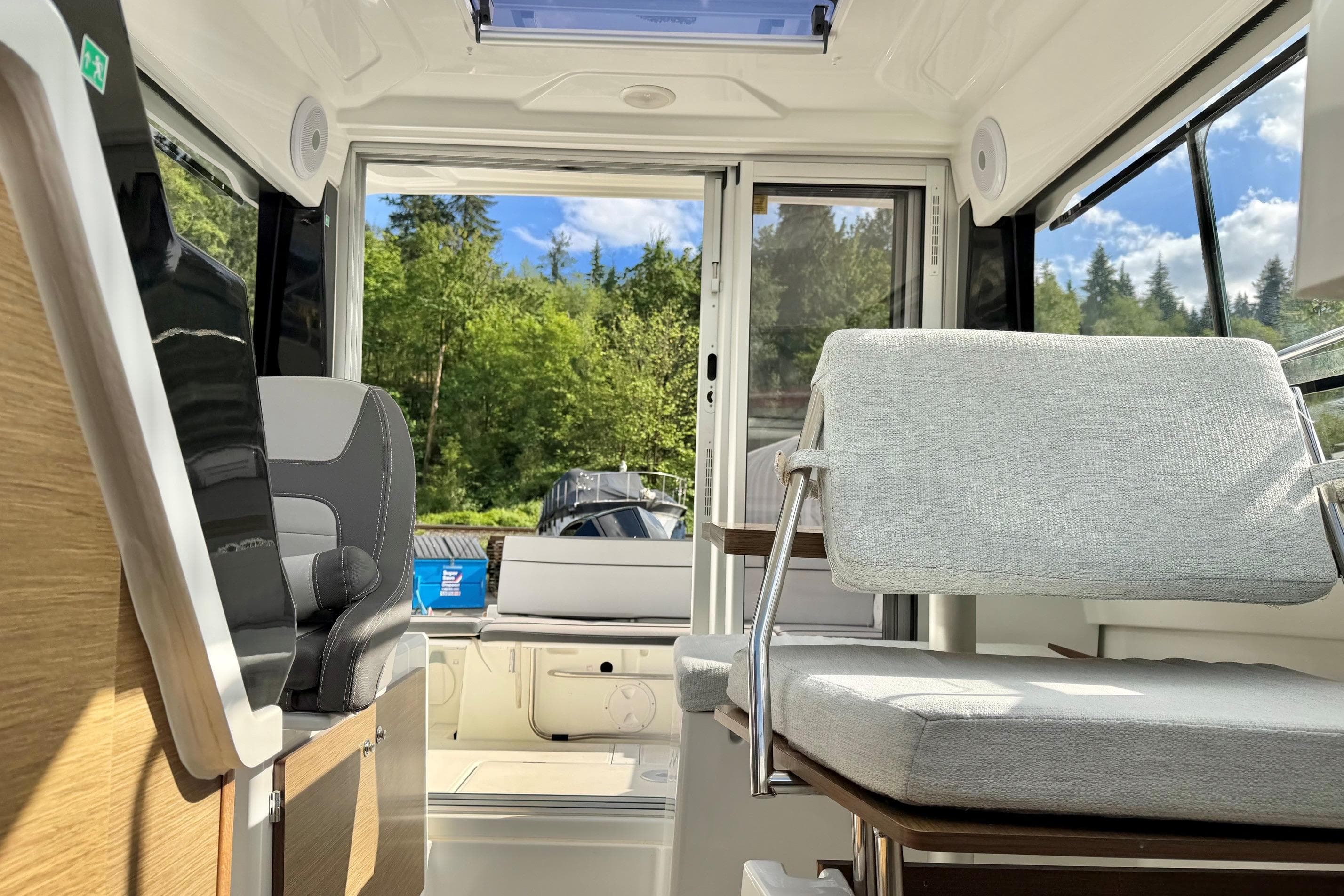 Interior of 2023 Jeanneau NC Sport 695 Series 2 boat with modern seating and scenic view.