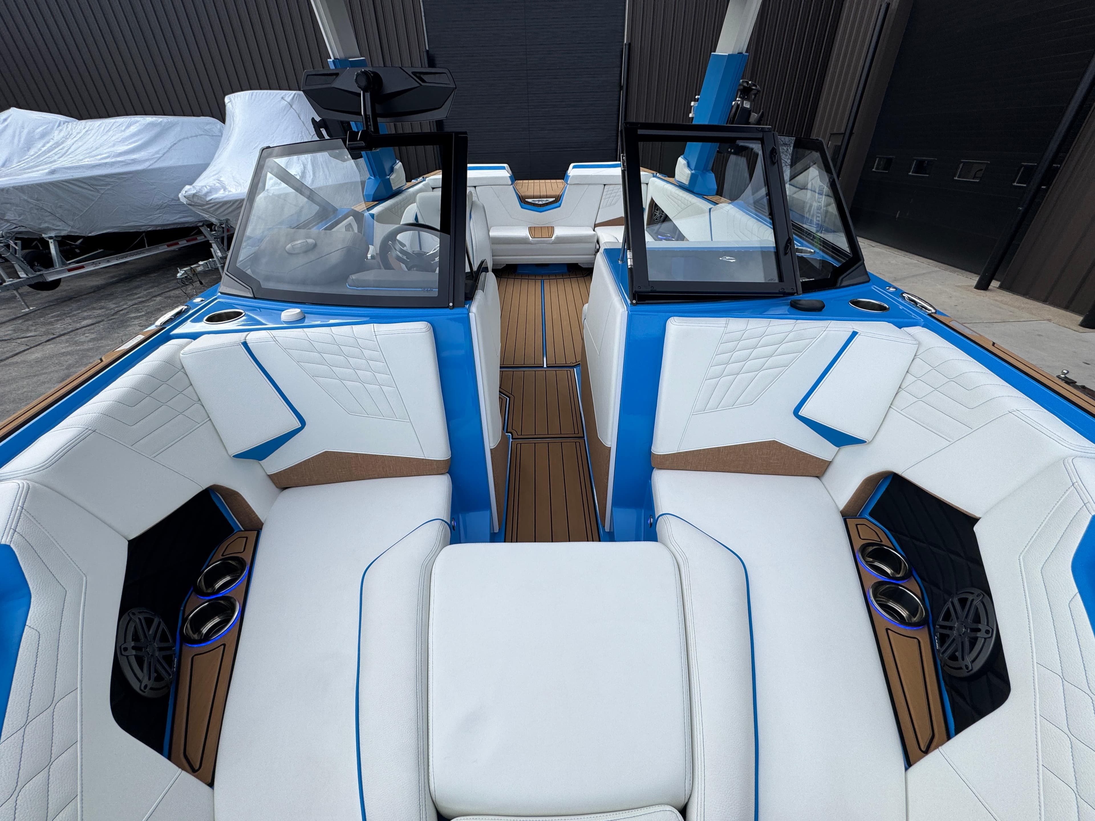 2025 Nautique Super Air Nautique S23 interior with white and blue seating, wood accents.