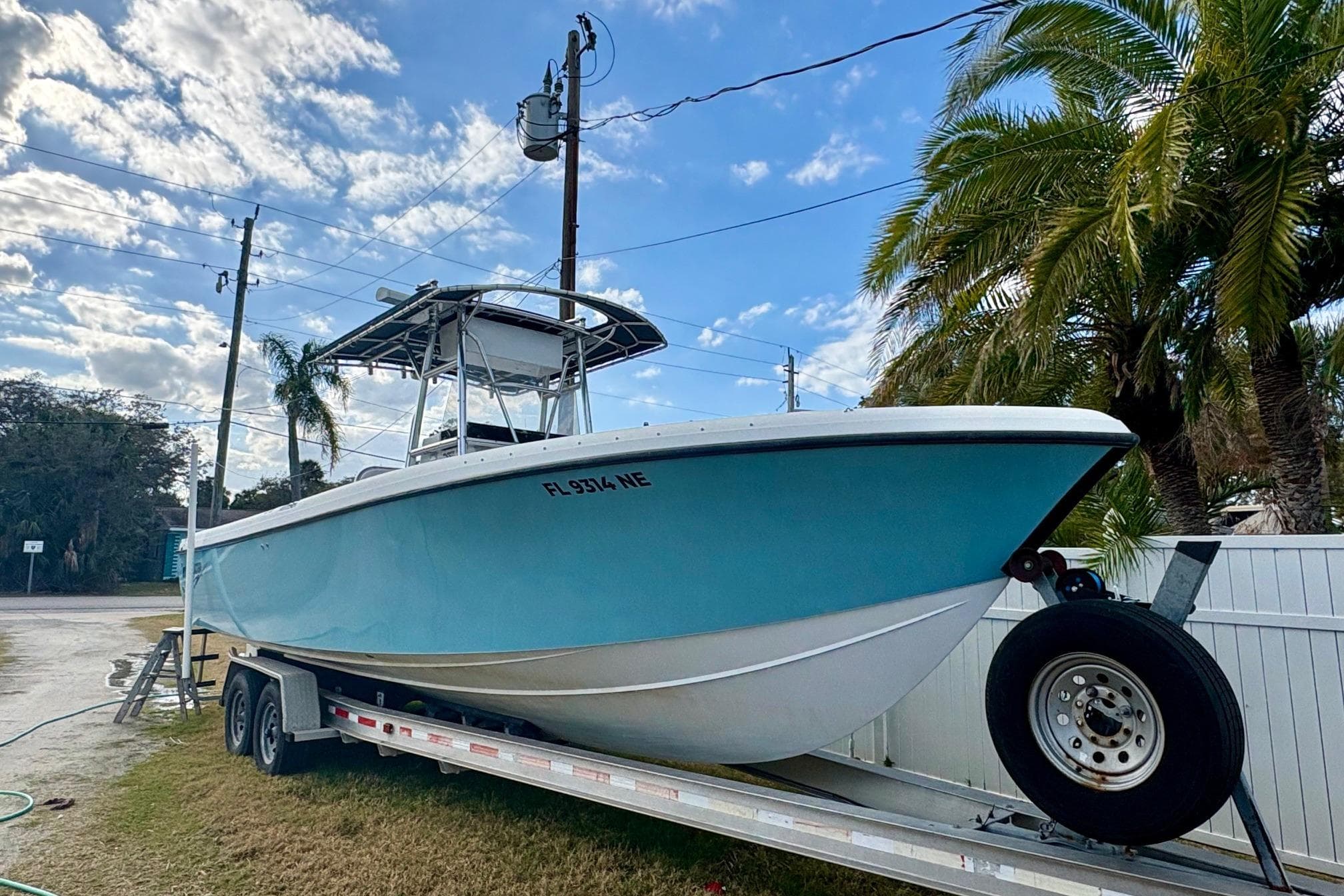 2006 Bluewater 2850 CC boat on trailer, parked outdoors under a blue sky.