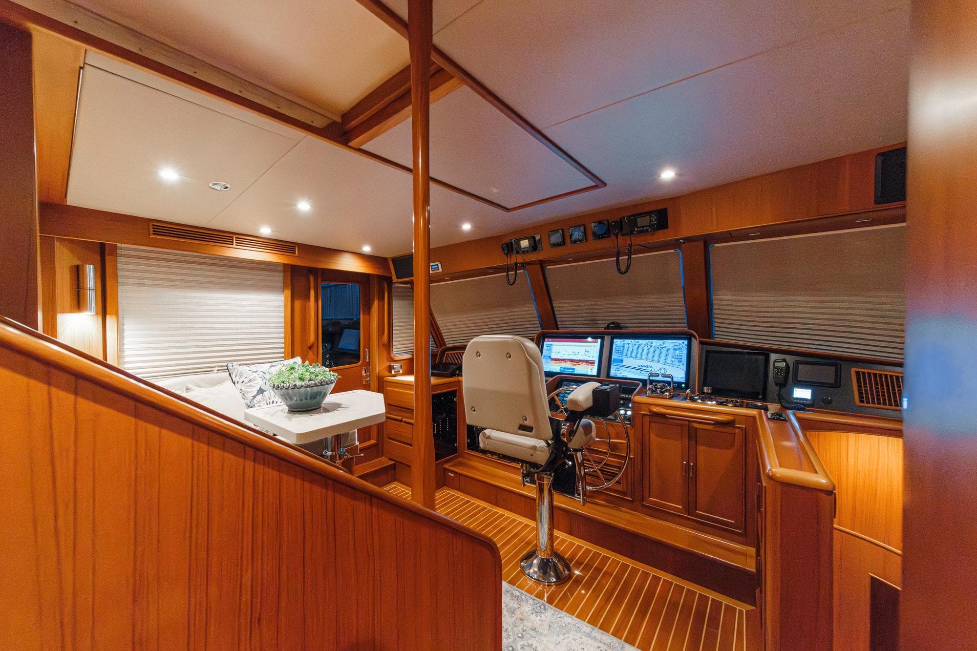 Luxurious 2018 Fleming 58 Pilothouse interior with modern navigation equipment and elegant wood finish.