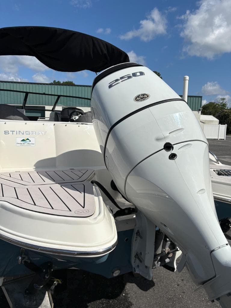 2021 Stingray 231 DC boat with a 250 horsepower outboard motor, docked under a clear sky.