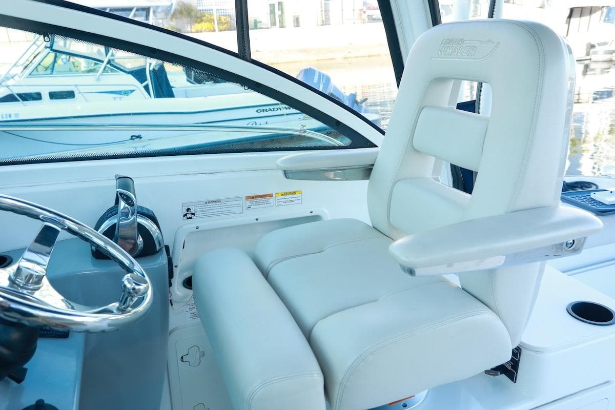 Captain's seat and helm of 2016 Boston Whaler 285 Conquest boat, featuring sleek design.