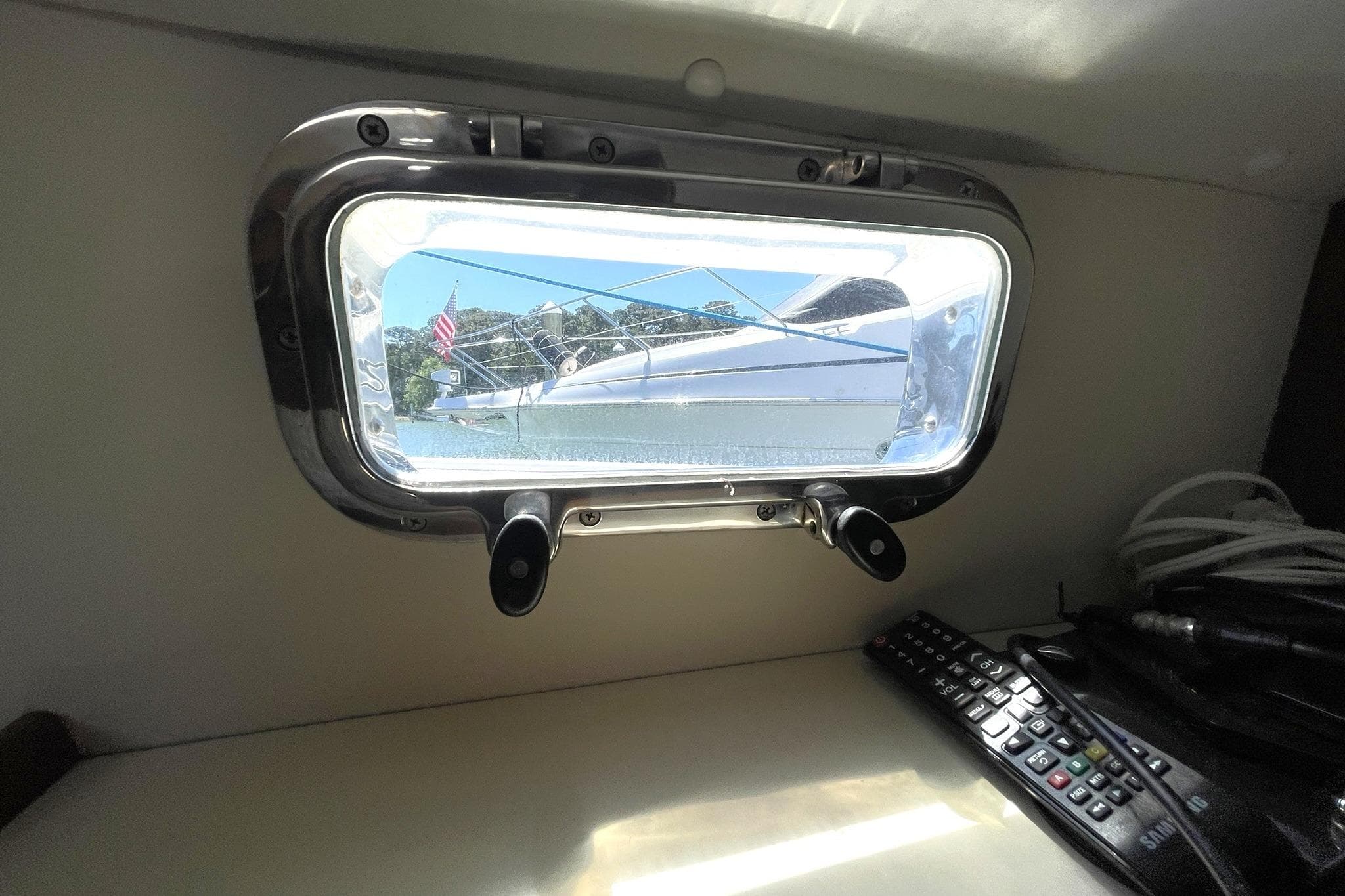 Interior view from a 1999 Legacy Yachts 40 Sedan, showing a porthole and remote control.