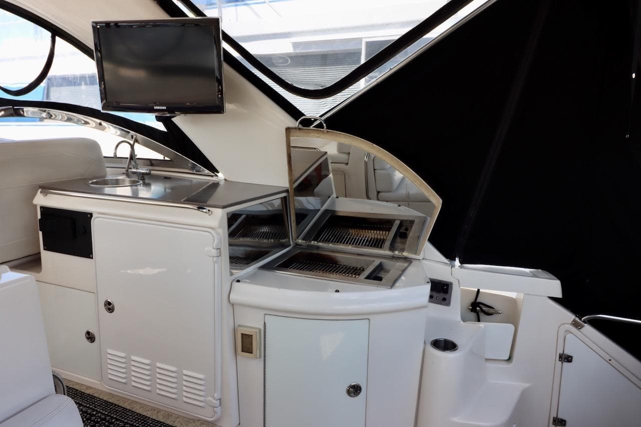 2006 Regal Commodore 4460 yacht interior with kitchenette and TV setup.