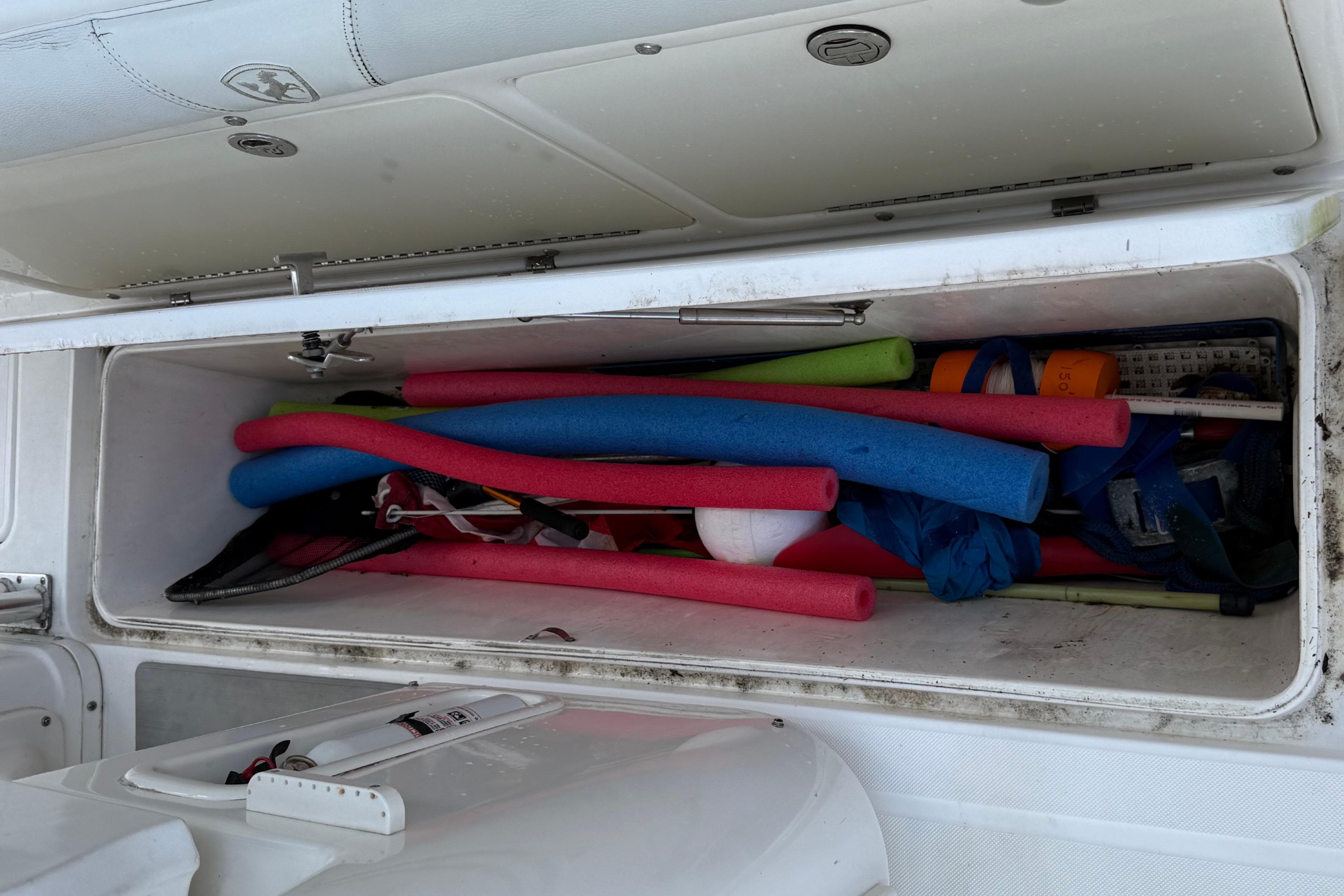 Storage compartment of 2008 Century 2901 Center Console filled with colorful pool noodles.