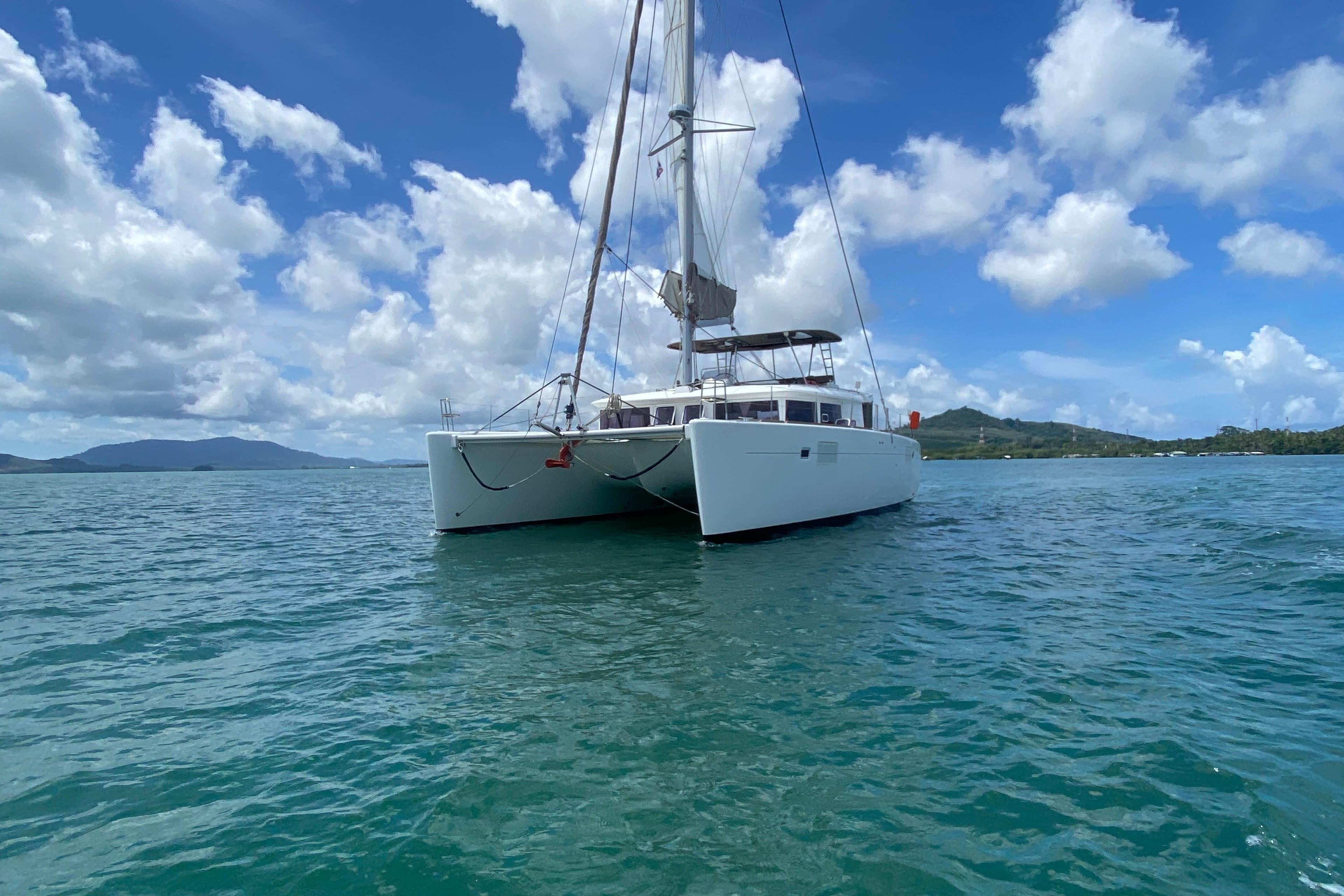 2015 Lagoon 450 F catamaran sailing on clear blue waters under a bright sky.