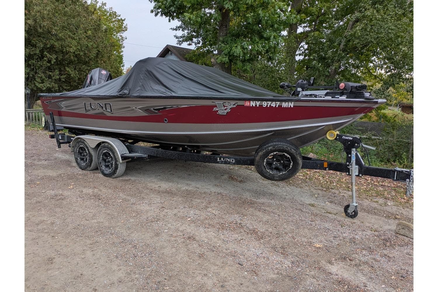 2019 Lund 2175 Pro-V boat on trailer, covered, parked outdoors.