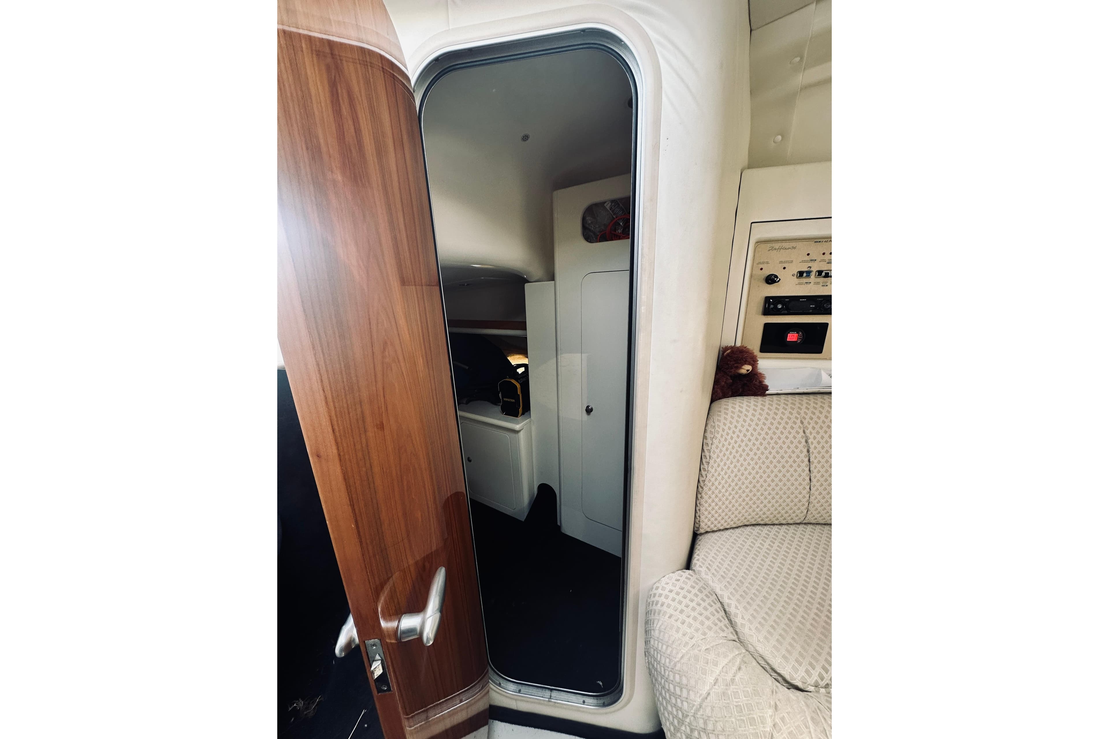 Interior view of 1999 Cranchi Endurance 39 yacht, featuring wooden door and plush seating.