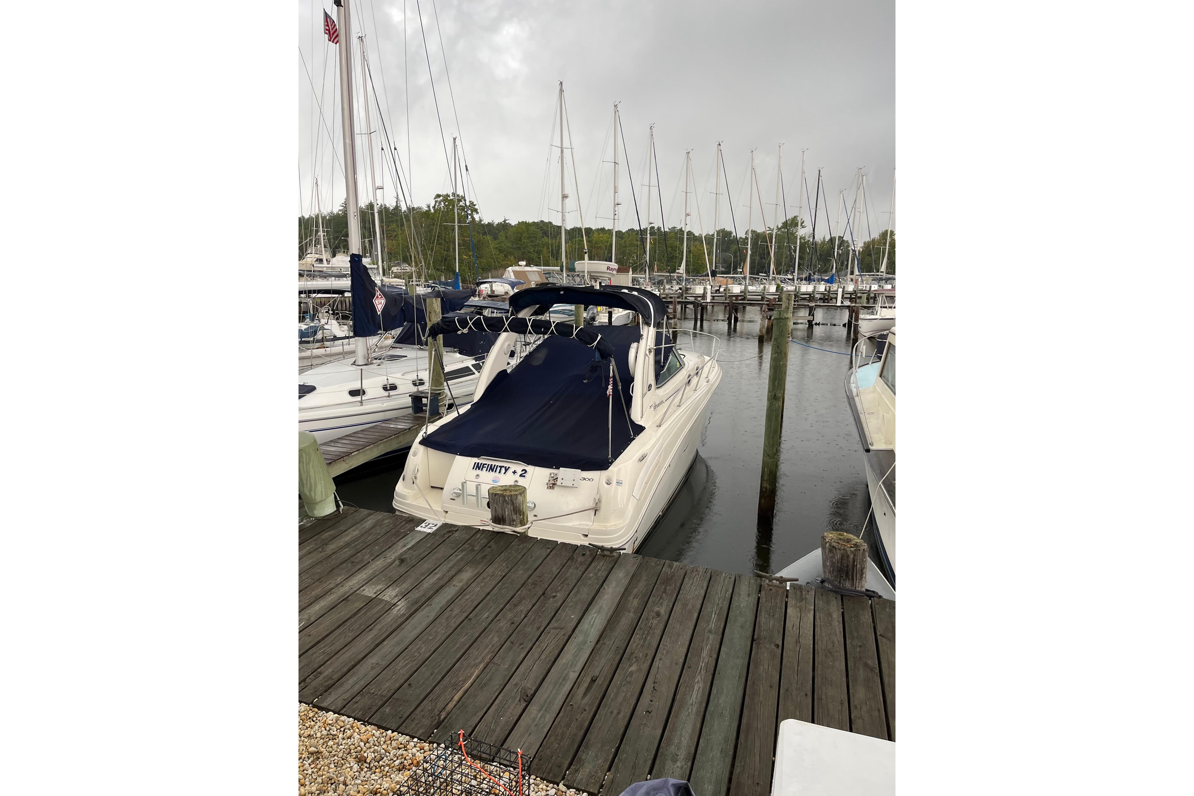 2006 Sea Ray 300 Sundancer docked at a marina on a cloudy day.
