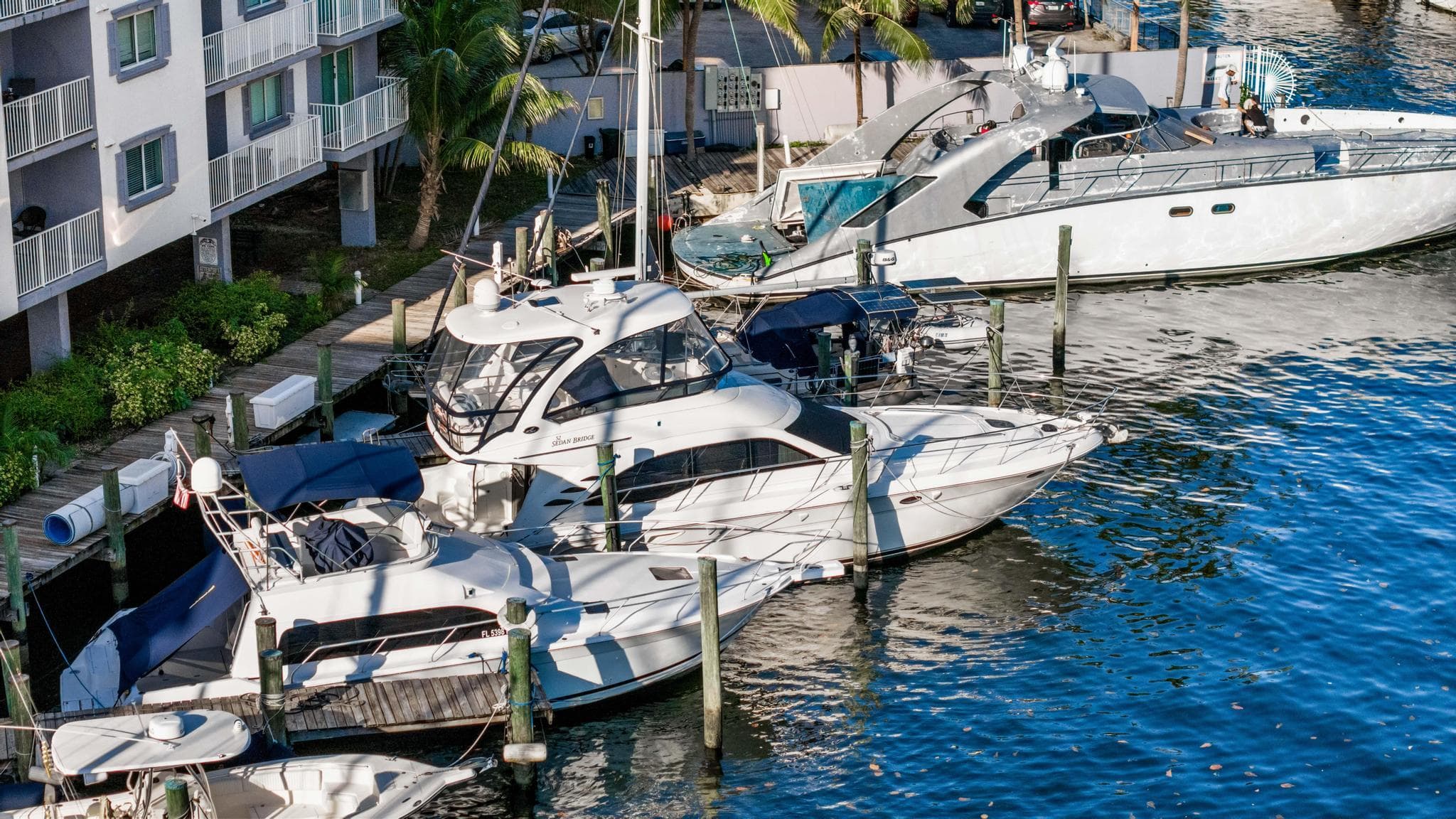 2007 Sea Ray 52 Sedan Bridge yacht docked at marina near waterfront buildings.