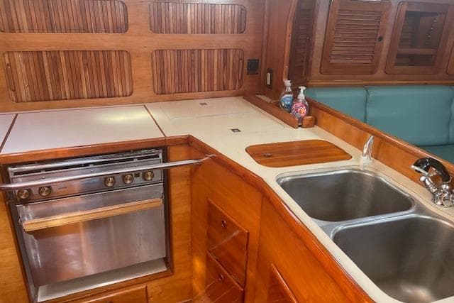 1993 Sabre 38 yacht interior galley with wood finish, dual sink, and stove.