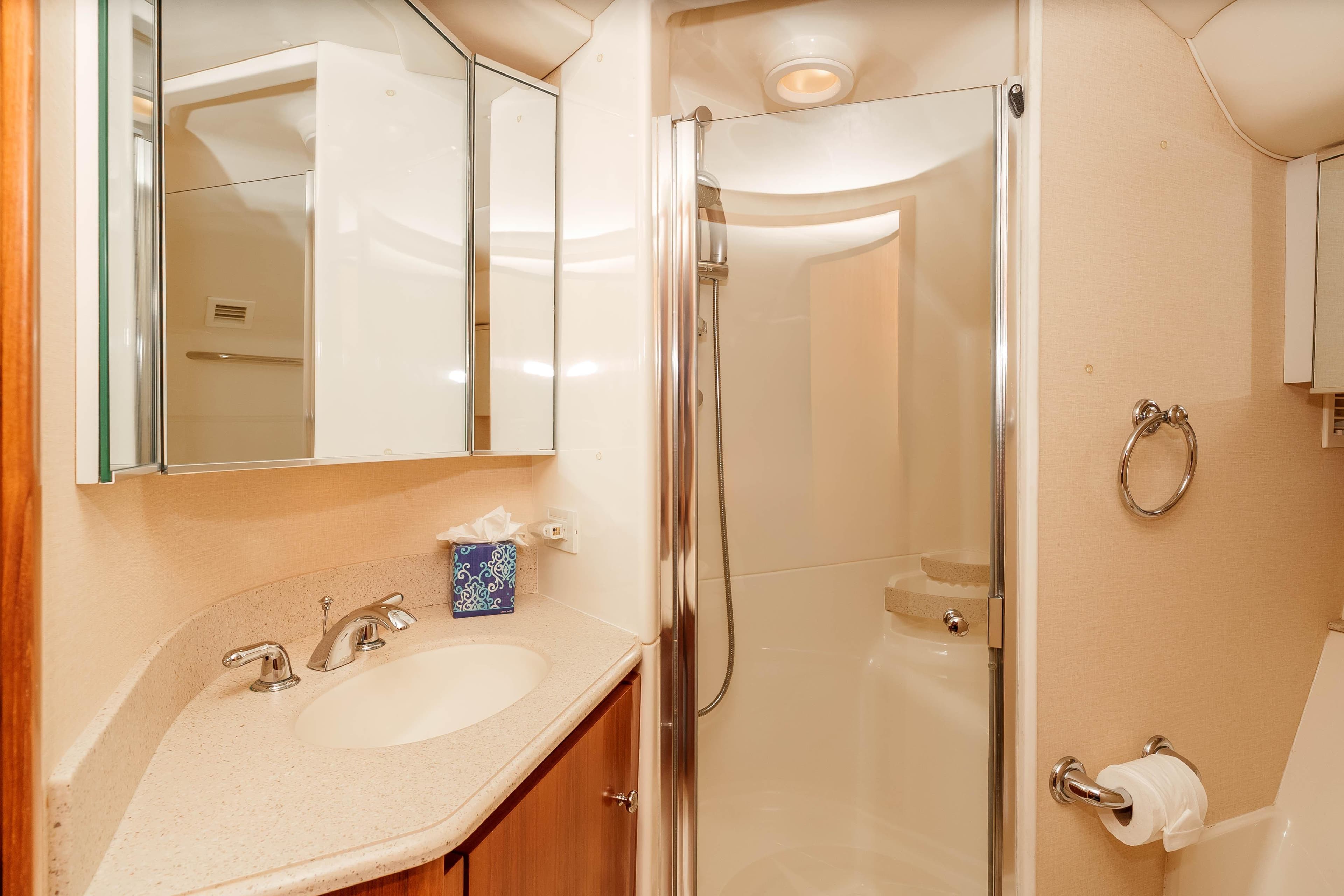 Luxurious bathroom in 2006 Tiara Yachts 5200 Sovran Salon with shower and vanity.