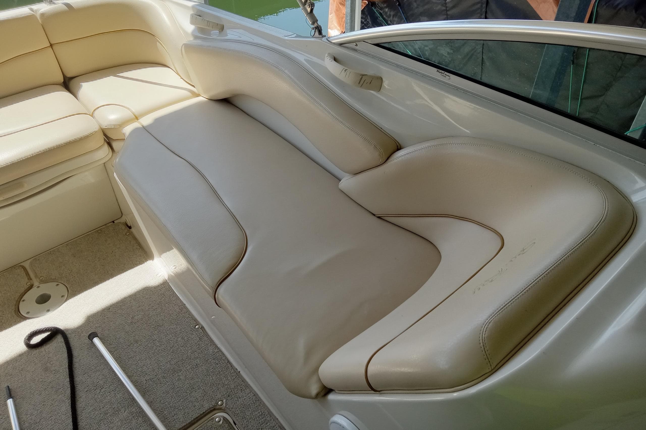 2001 Sea Ray 240 Sundeck interior with beige seating and carpeted floor.