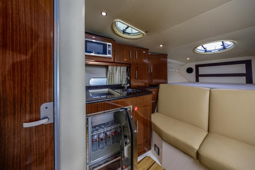 2014 Regal 32 Express yacht interior with kitchenette, fridge, and seating area.