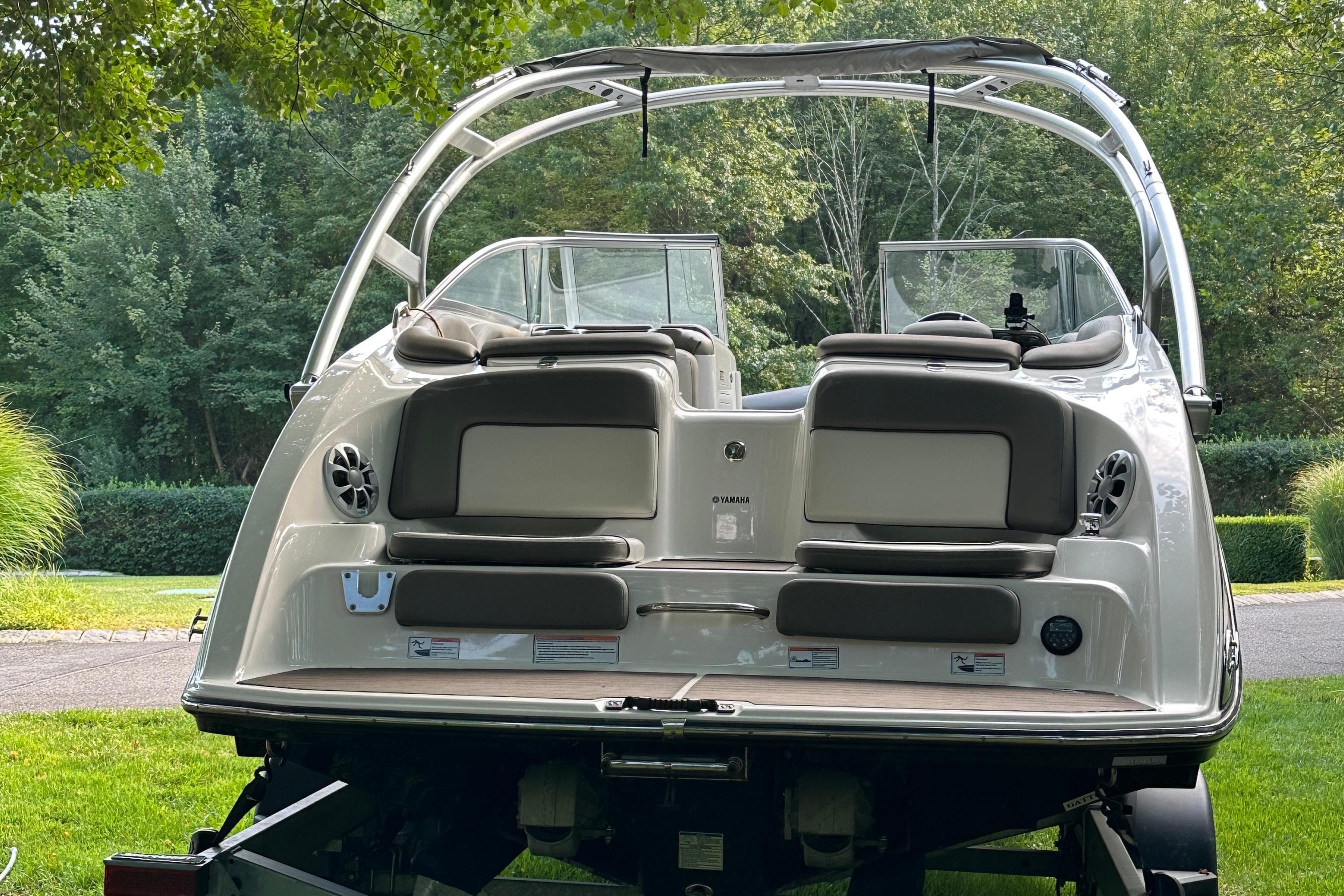 2012 Yamaha Boats 242 Limited S on trailer, rear view in lush green setting.