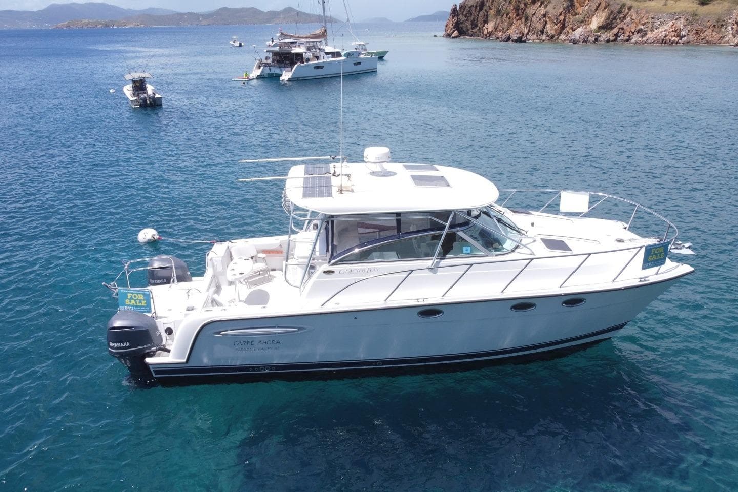 2004 Glacier Bay 3470 Ocean Runner boat for sale, anchored in clear blue waters.