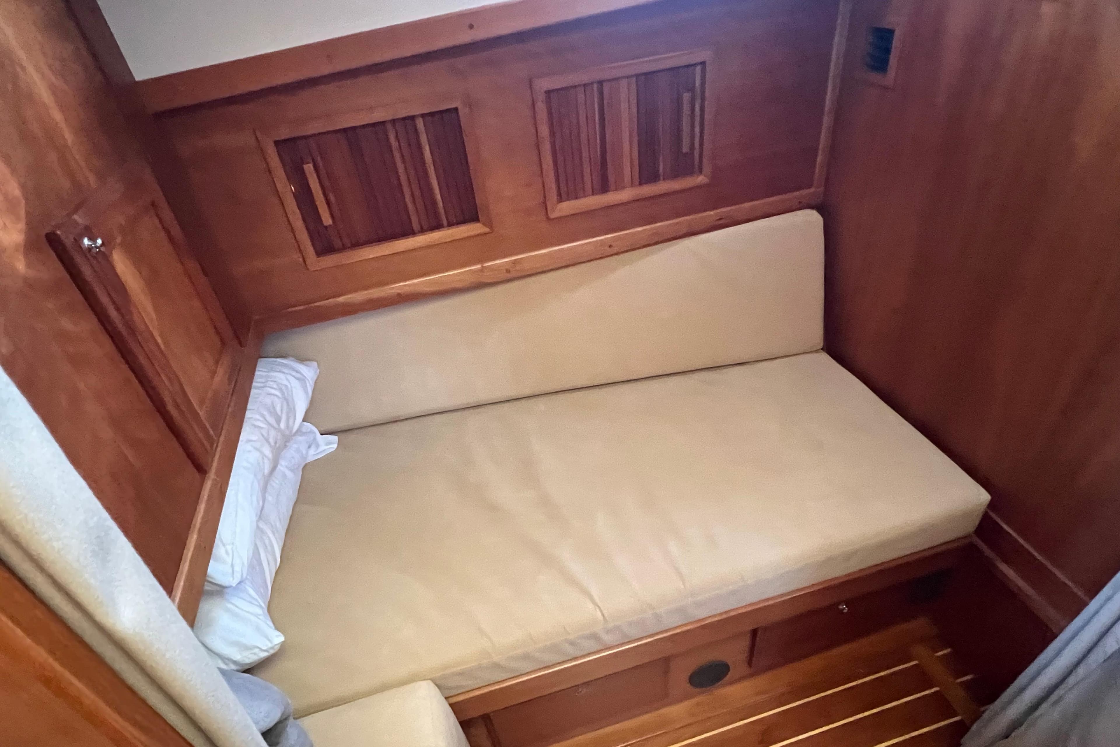 2005 Sabre Flybridge cabin interior with wooden finish and cozy bed.