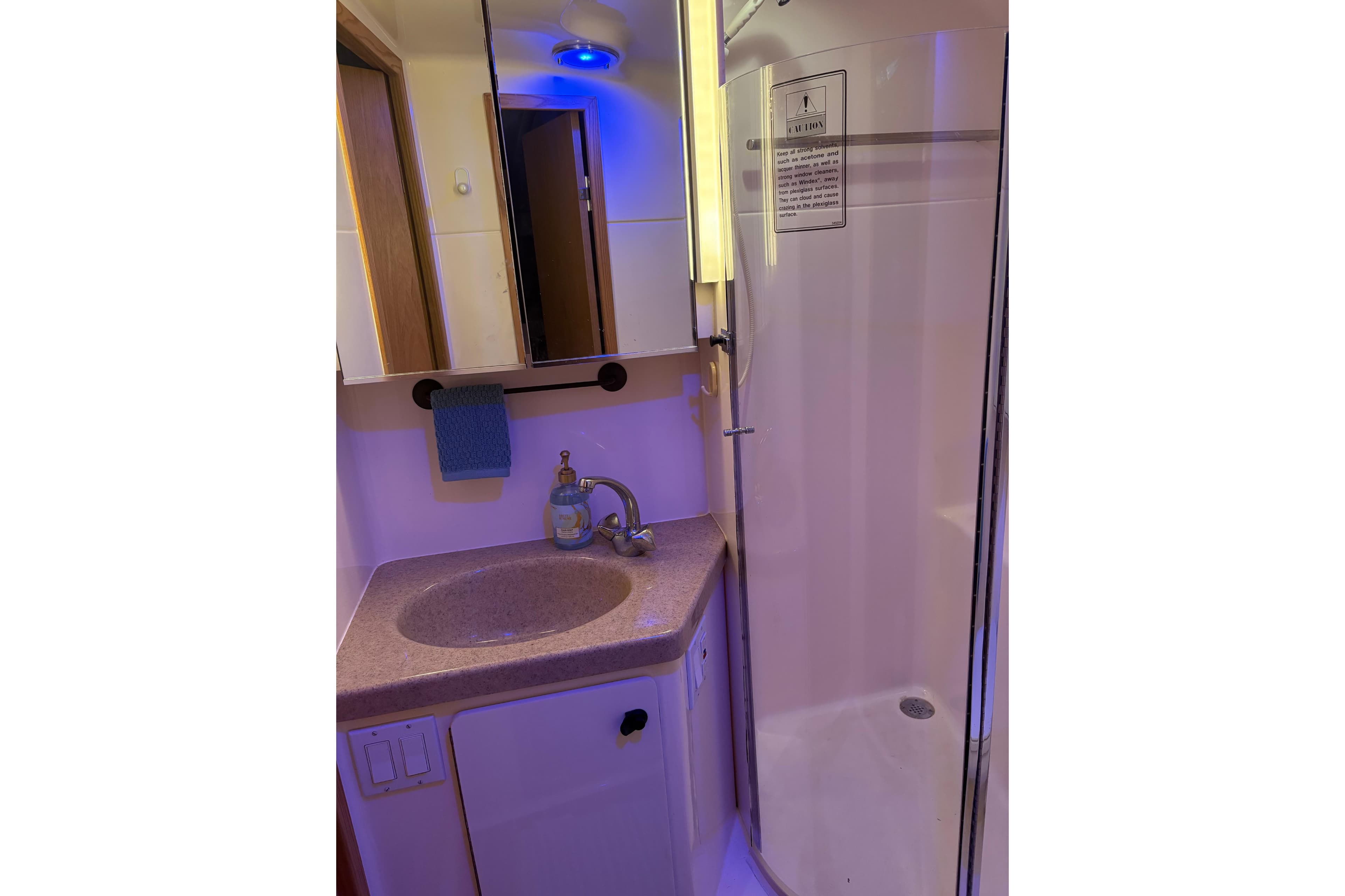 1999 Tiara Yachts 4000 Express bathroom with sink, mirror, and shower.