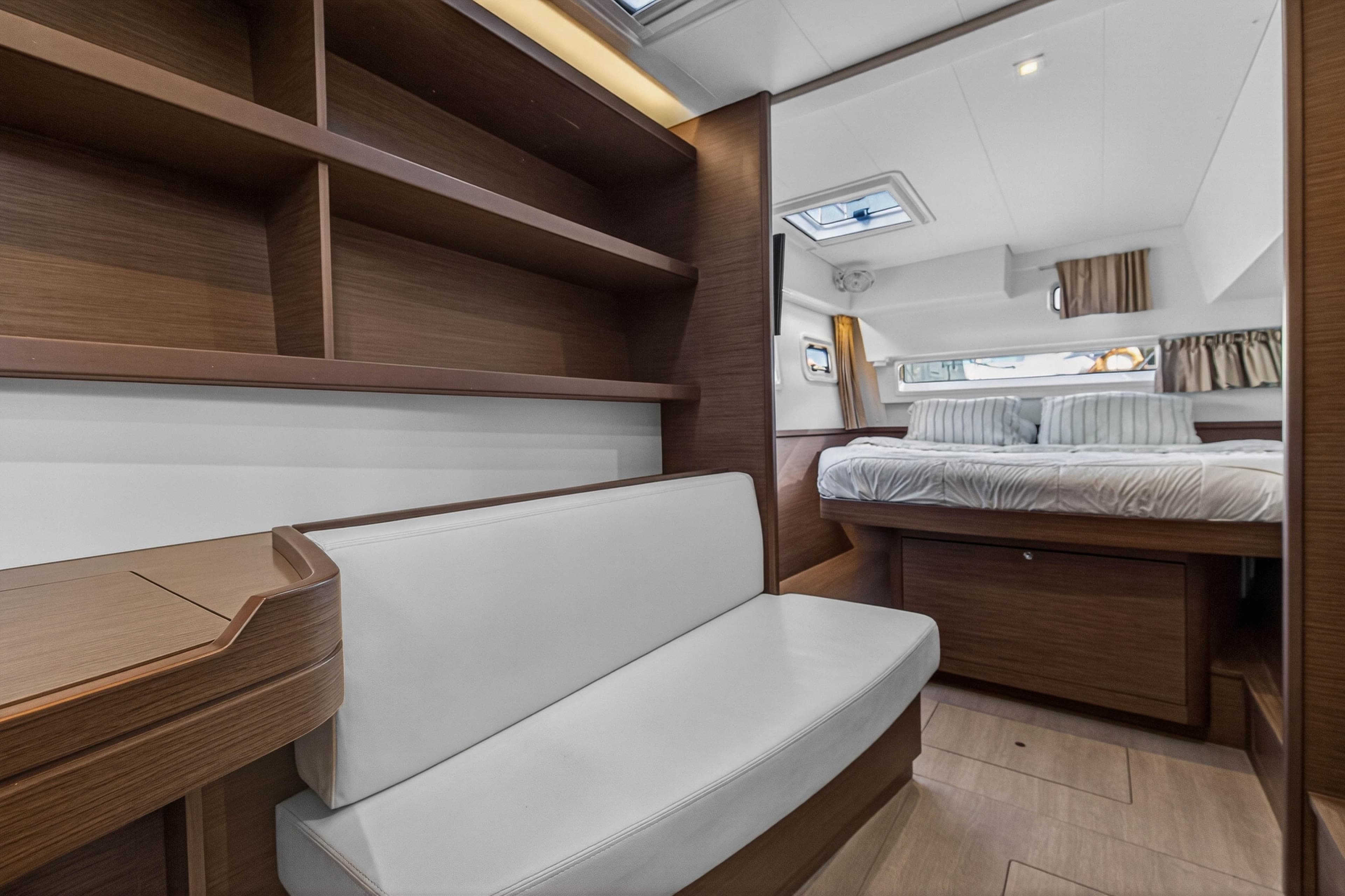 Luxurious interior of 2019 Lagoon 42 yacht with cozy bedroom and elegant wood finishes.