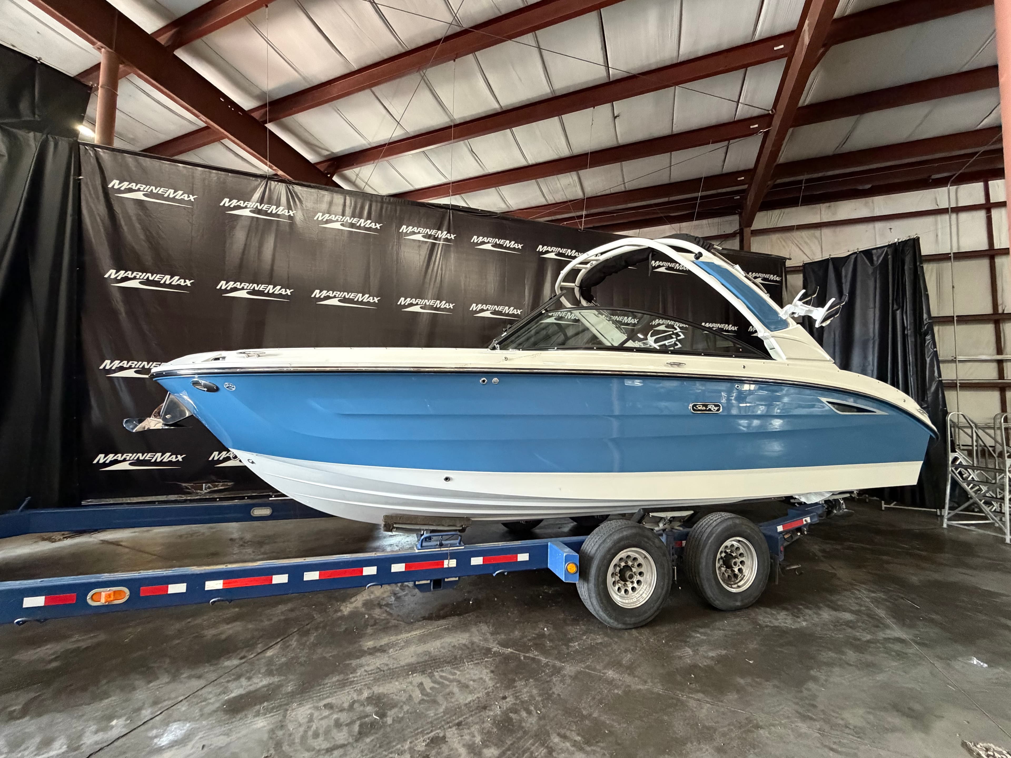 2026 Sea Ray SDX 270 Surf boat on trailer in warehouse.