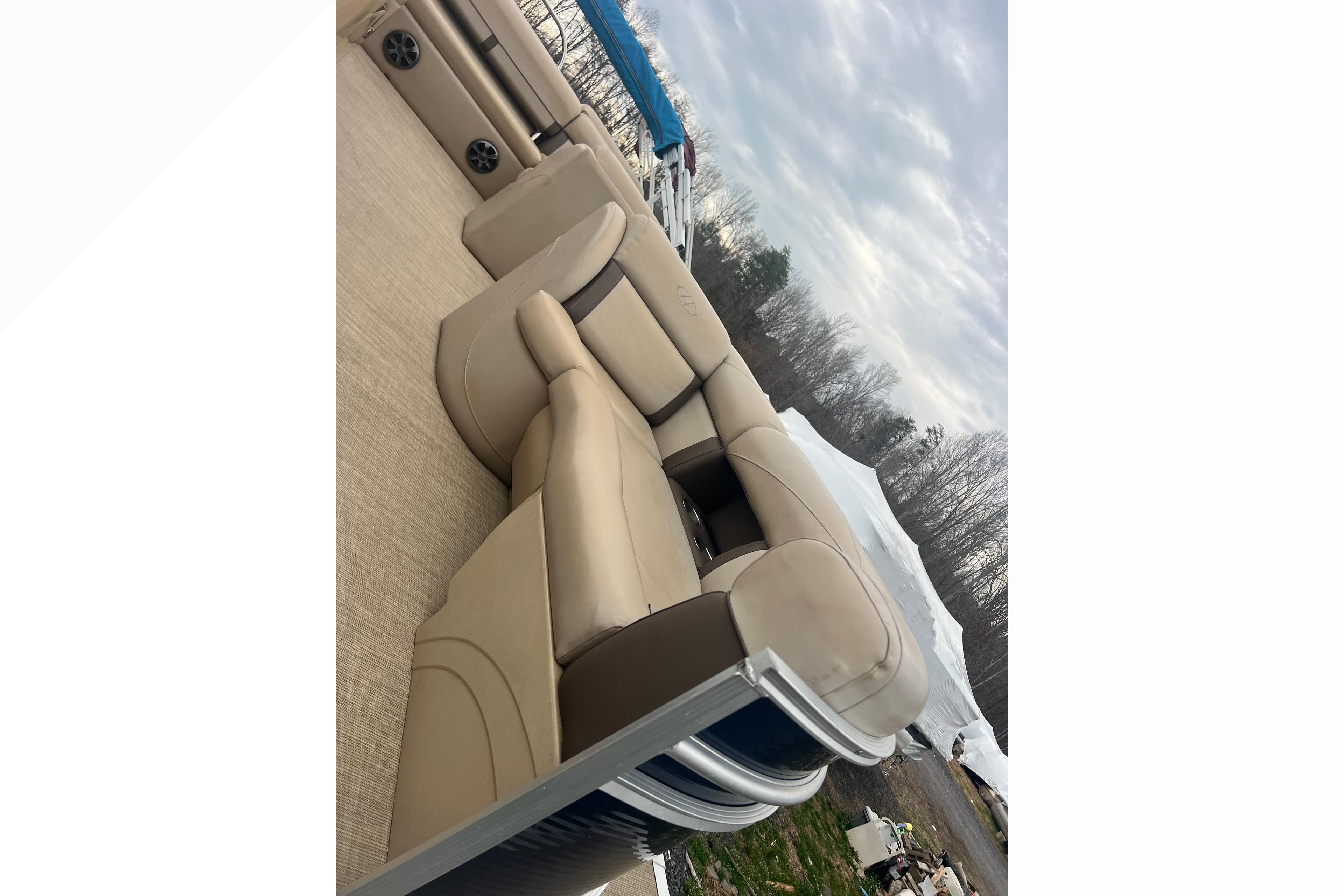 2019 Harris Cruiser 210 pontoon boat with beige seating and outdoor setting.
