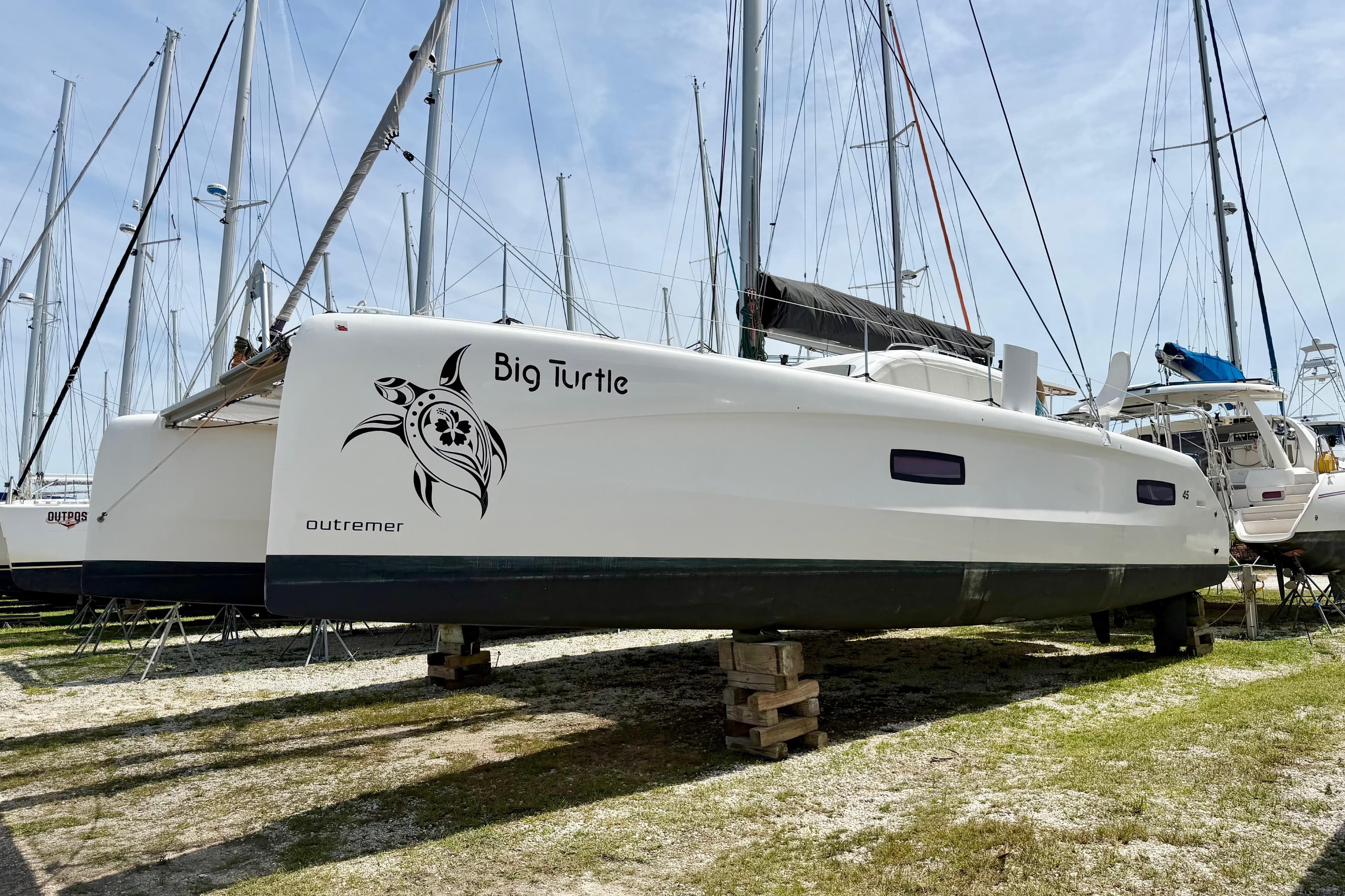 2016 Outremer 45 catamaran "Big Turtle" on land, surrounded by other sailboats.