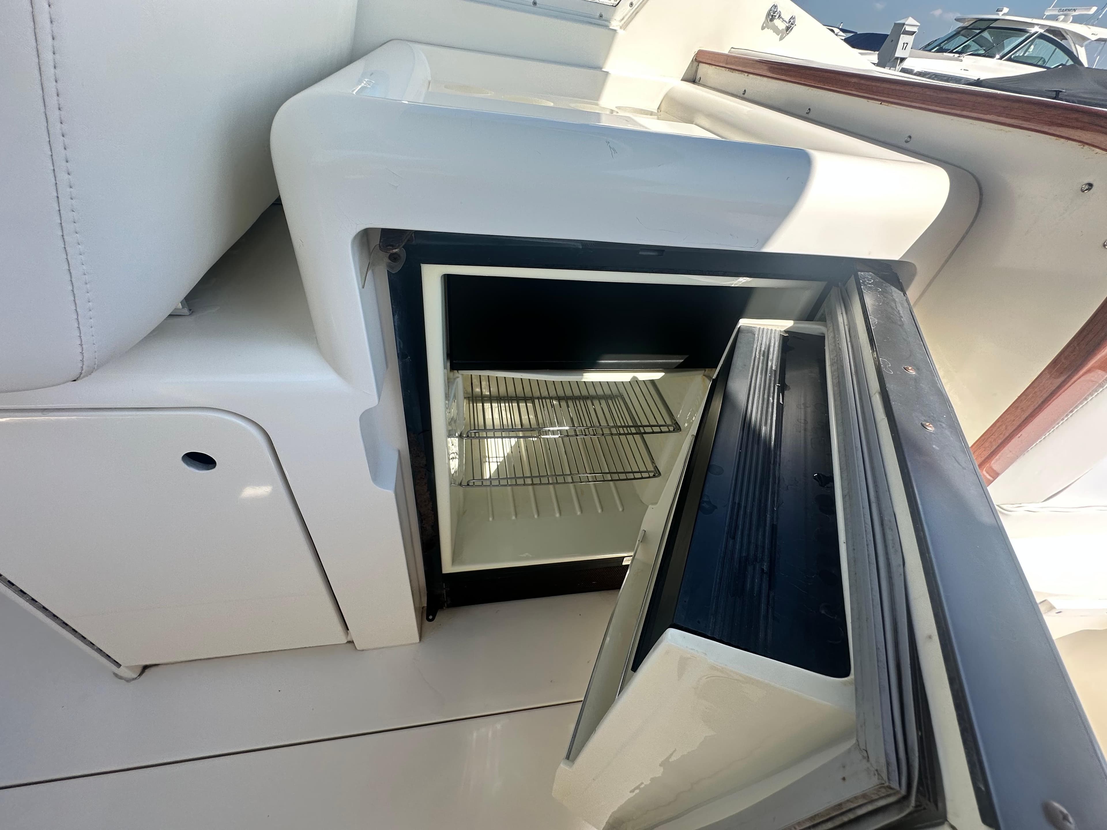 Open refrigerator on 1988 Bertram 28 Moppie boat, showcasing interior shelves.