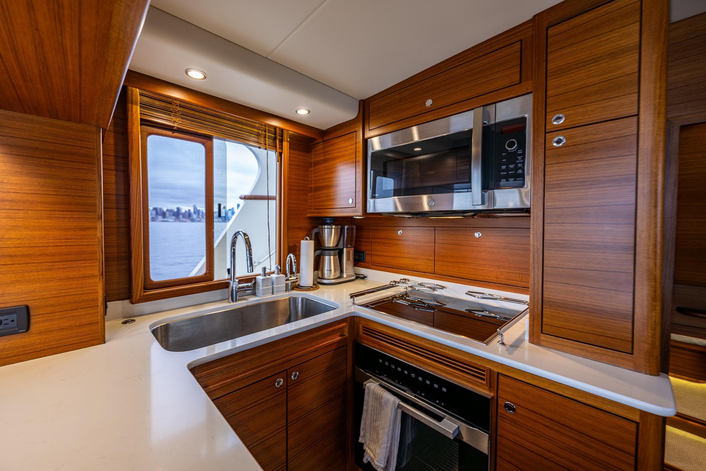 Luxurious kitchen interior of 2026 Fleming 55 Pilothouse yacht with modern appliances and wood finish.