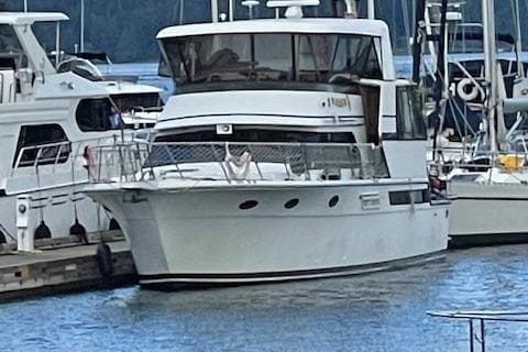 1991 Californian 52 Cockpit Motor Yacht docked at marina, surrounded by other boats.