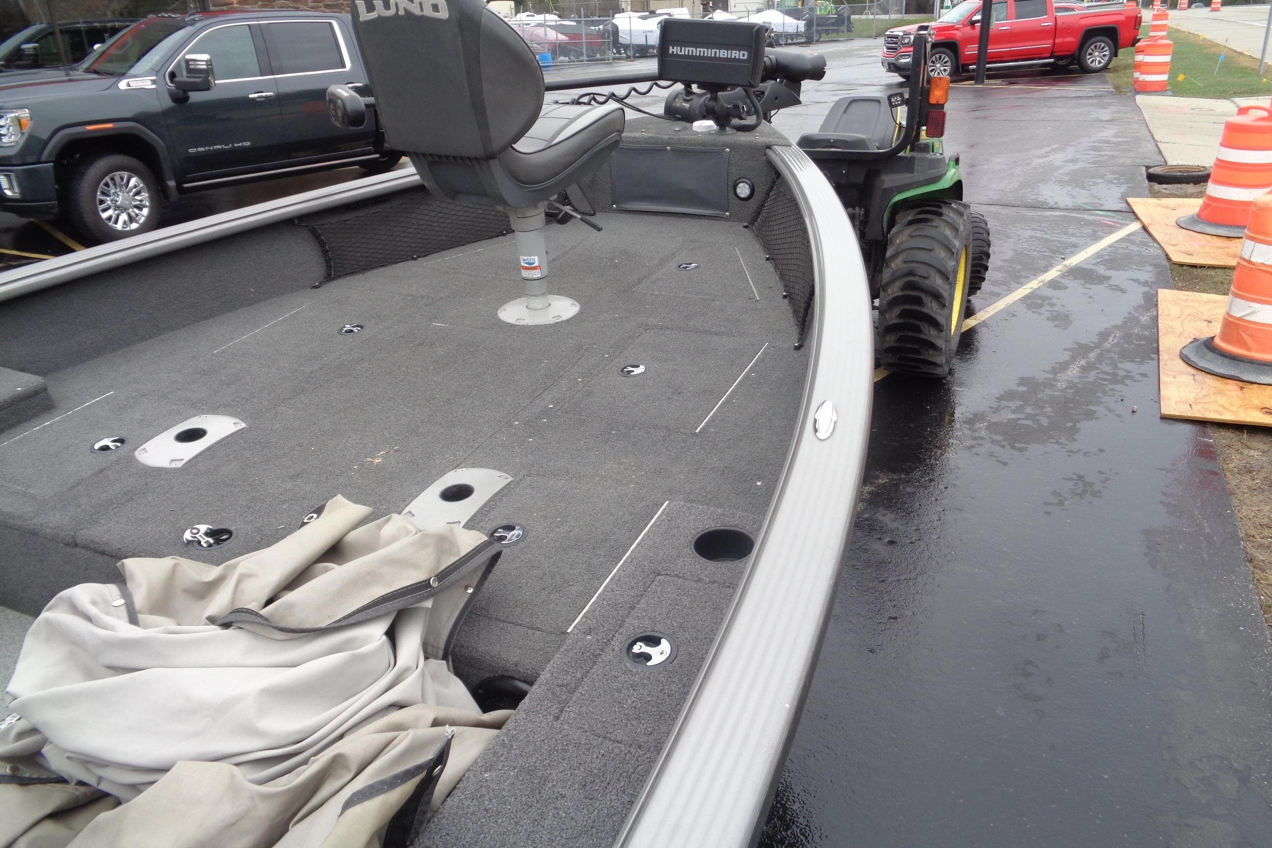 2011 Lund 2010 Pro Guide boat with seating, parked near construction cones.