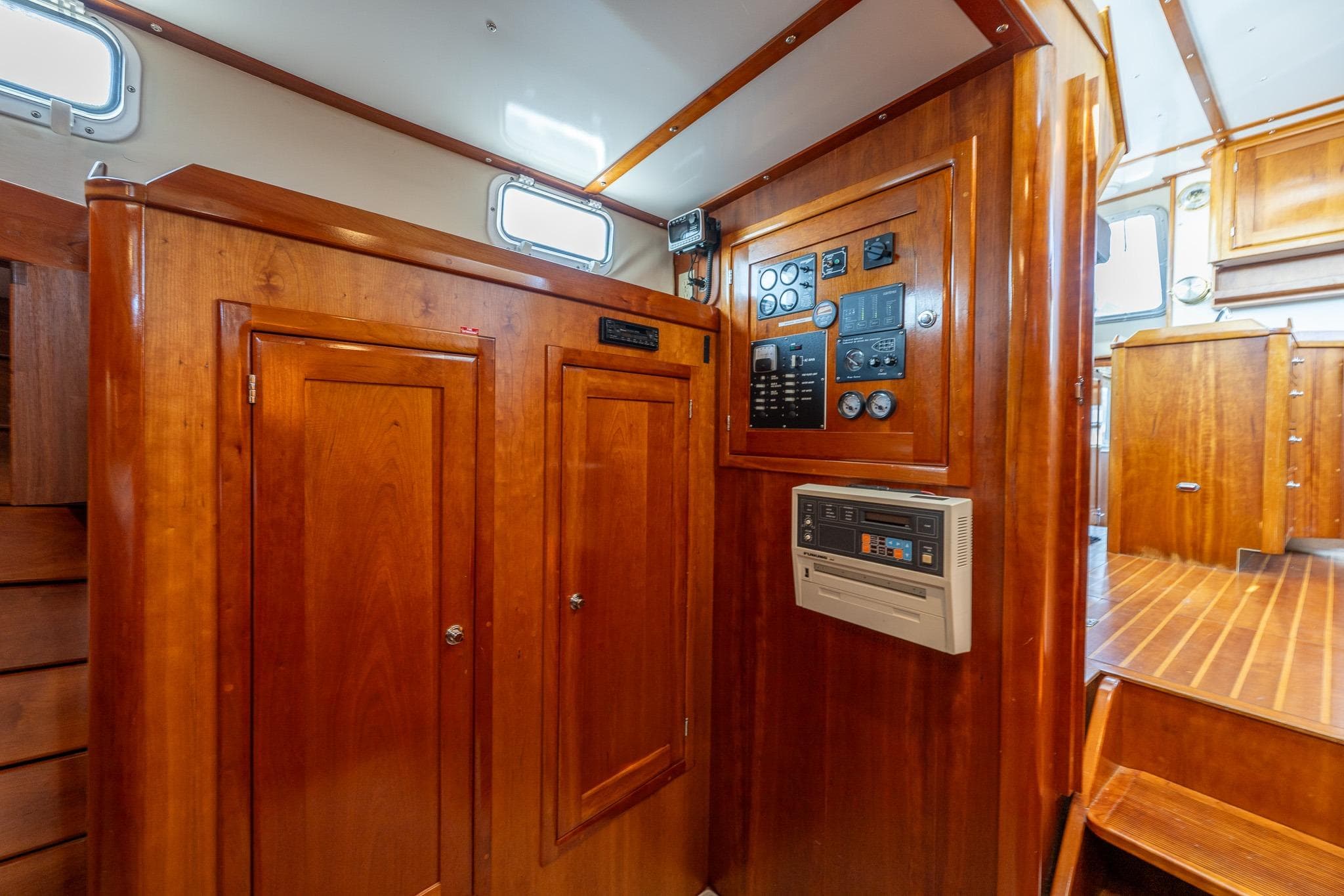 Interior of 1999 Rozema Boat Works Custom 40, featuring wooden cabinetry and control panel.