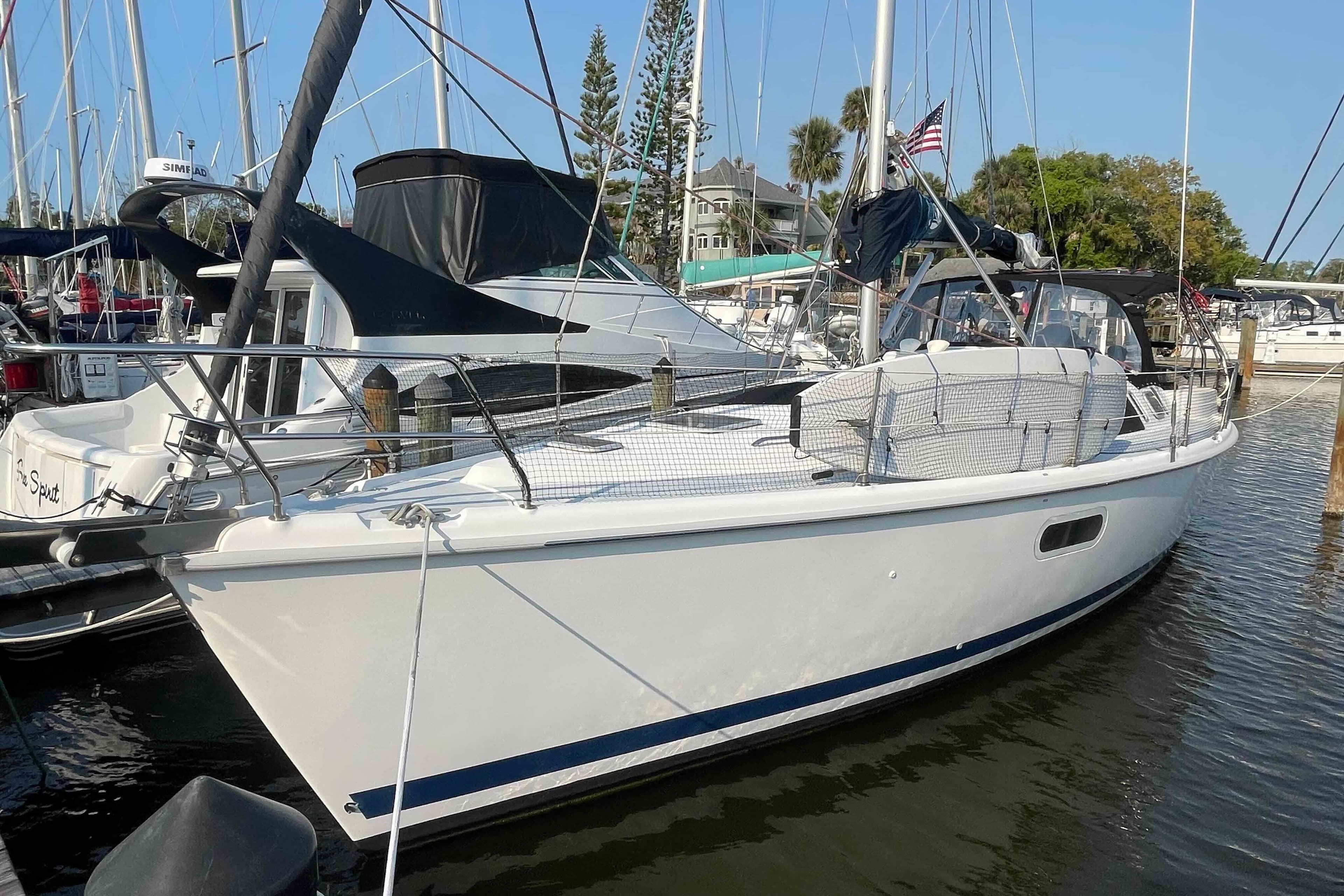 Sailboat docked in marina, 2000 Hunter 410 model, sunny day, calm waters.