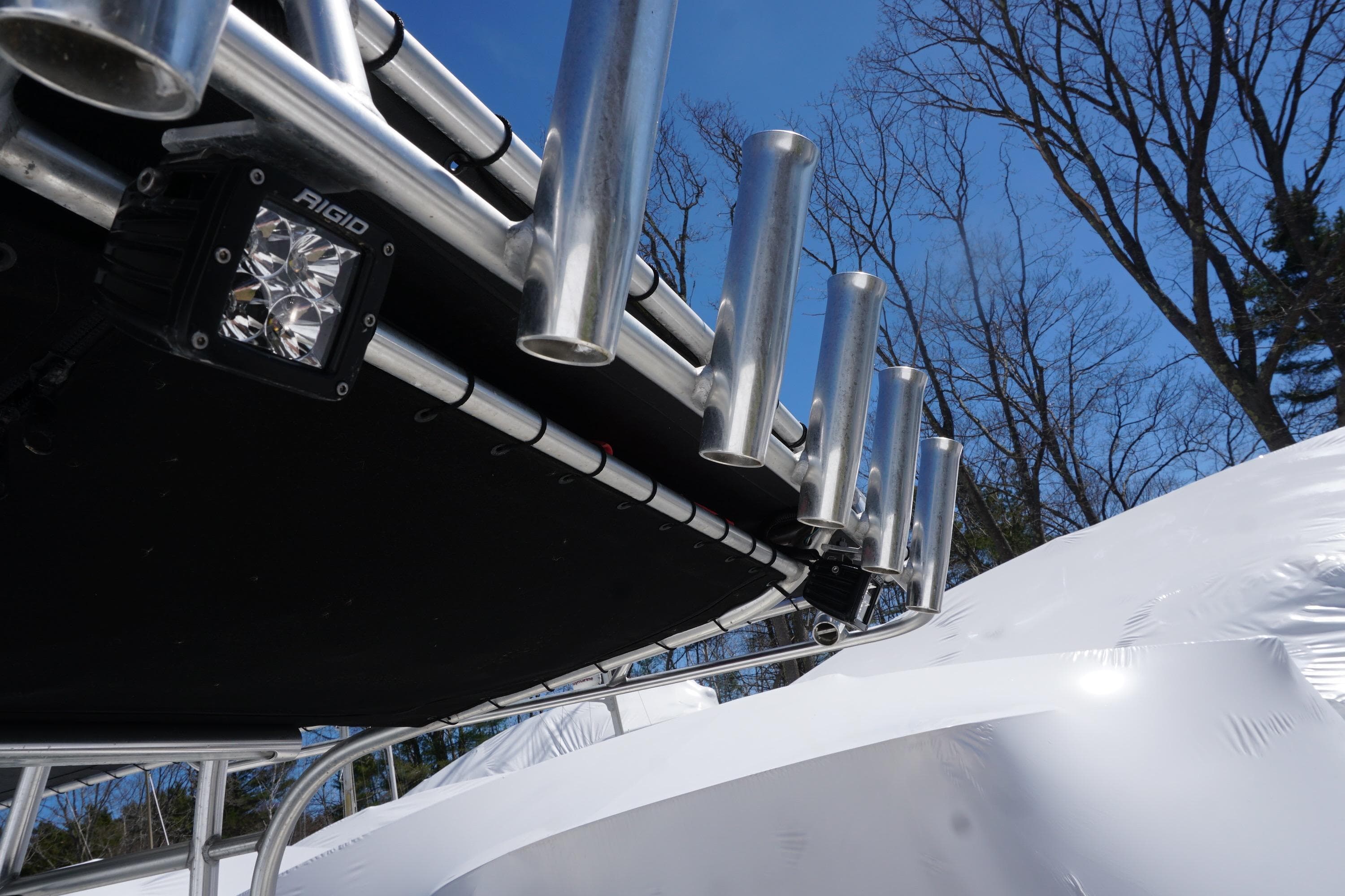 2012 Sailfish 2380 CC boat with rod holders and Rigid LED light, under clear blue sky.