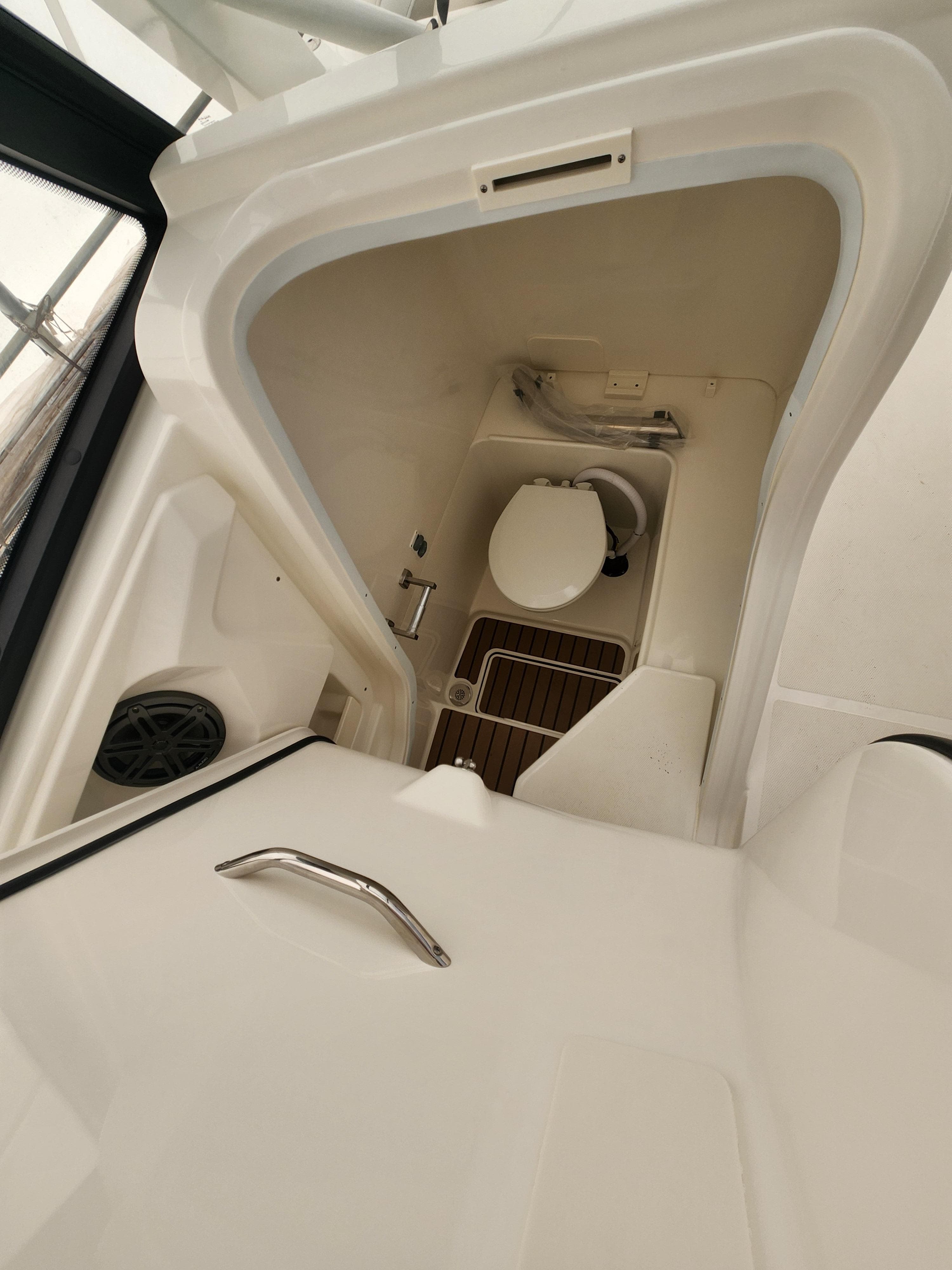 2025 World Cat 260 DC-X boat interior with compact marine toilet.